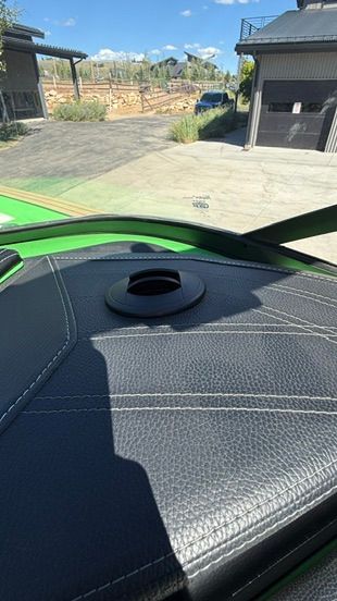 Close-up of a green boat roof with black upholstery and a round vent feature.