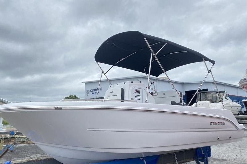 2025 Stingray 173CC boat with canopy, displayed outdoors under cloudy skies.