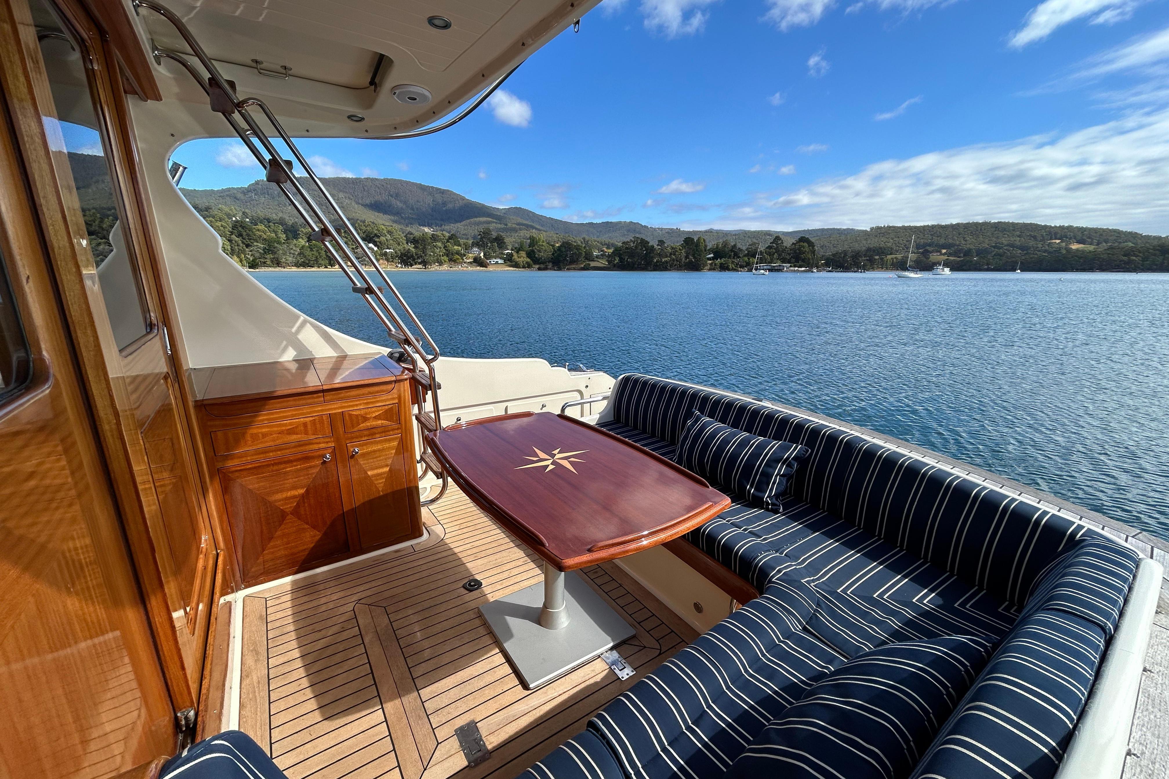 Luxurious 2008 Vicem 44 yacht deck with elegant seating and scenic water view.