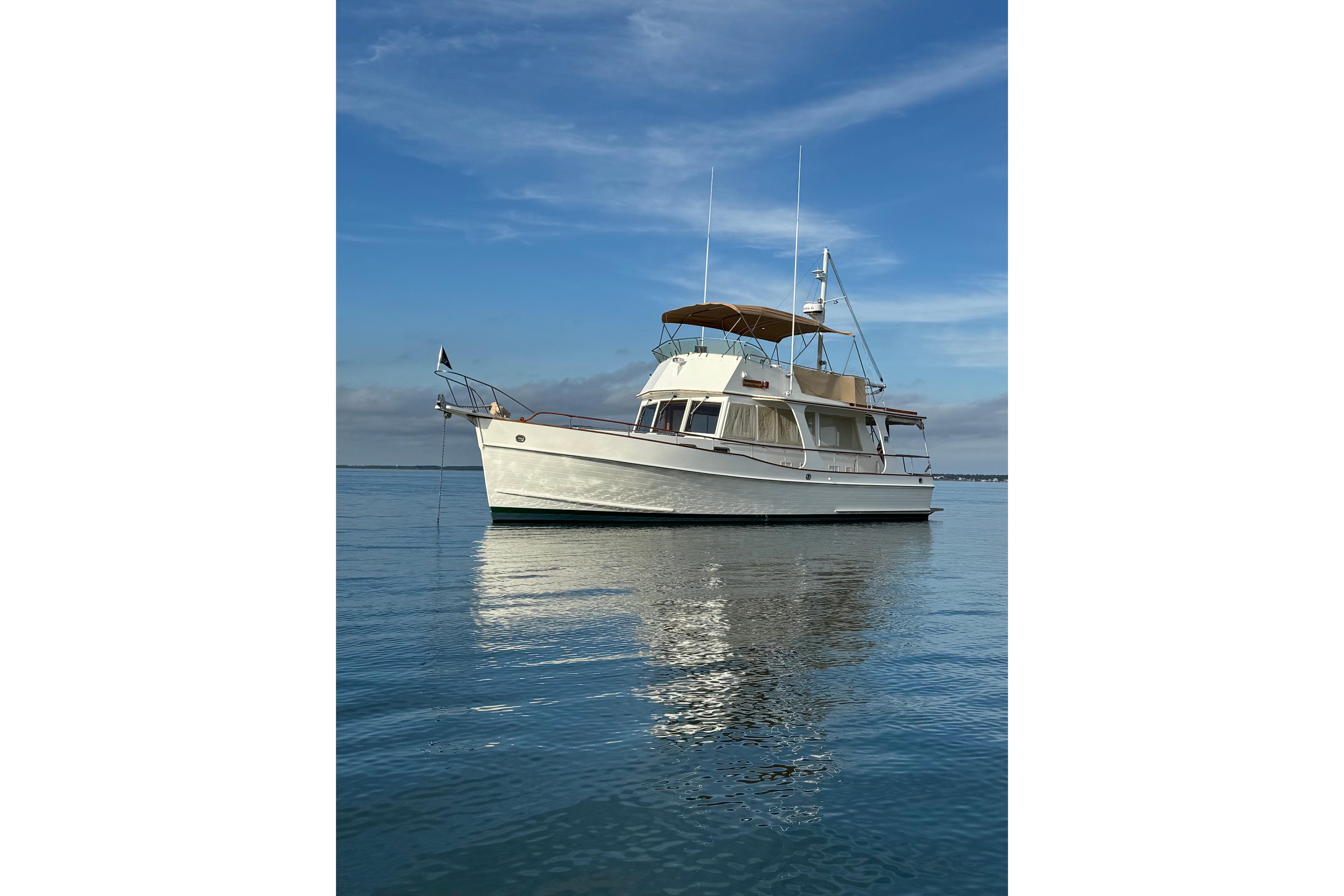 1999 Grand Banks 42 Europa yacht on calm water under a clear blue sky.