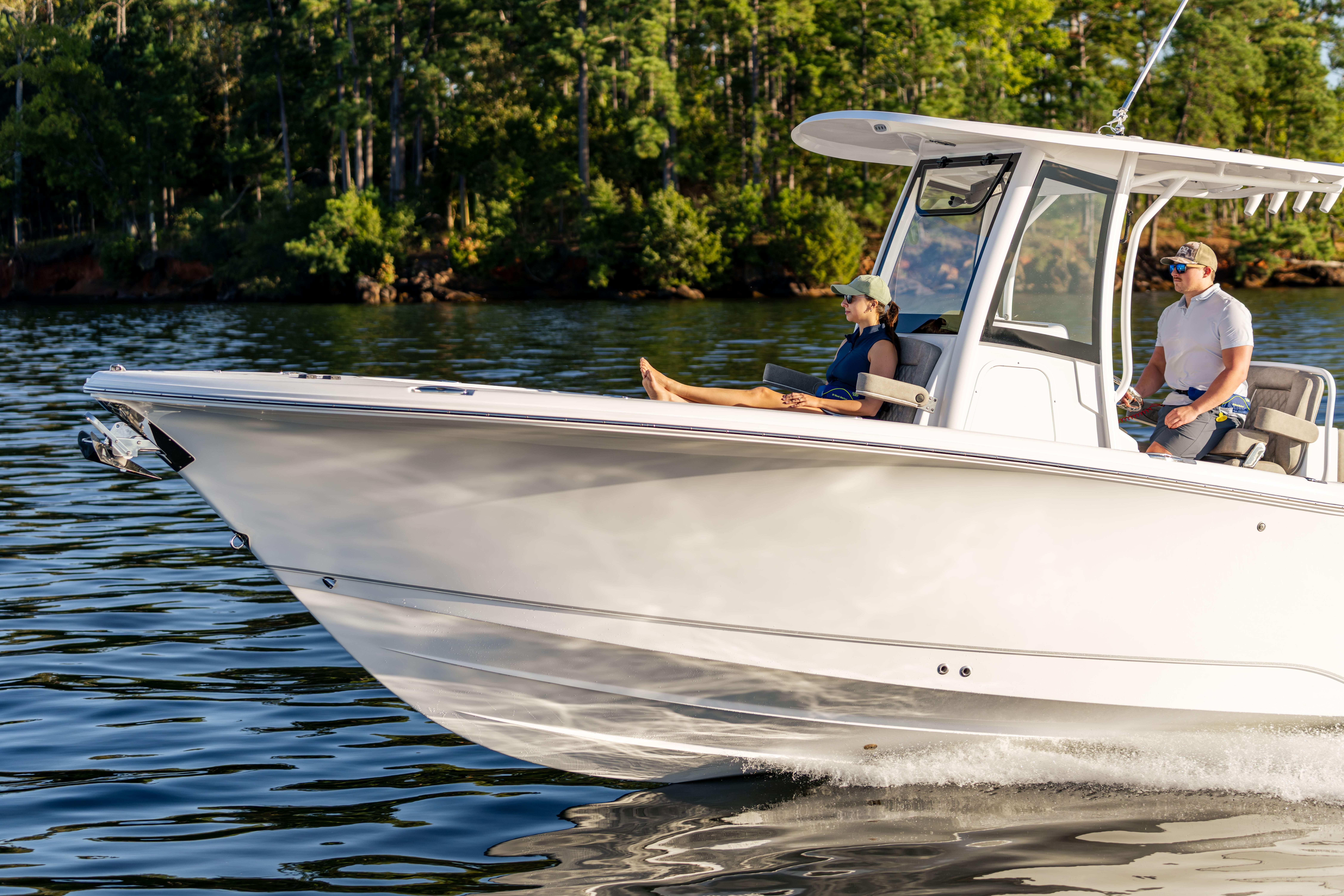 2026 Sea Hunt Ultra 275 Coffin Box cruising on a serene lake with passengers.