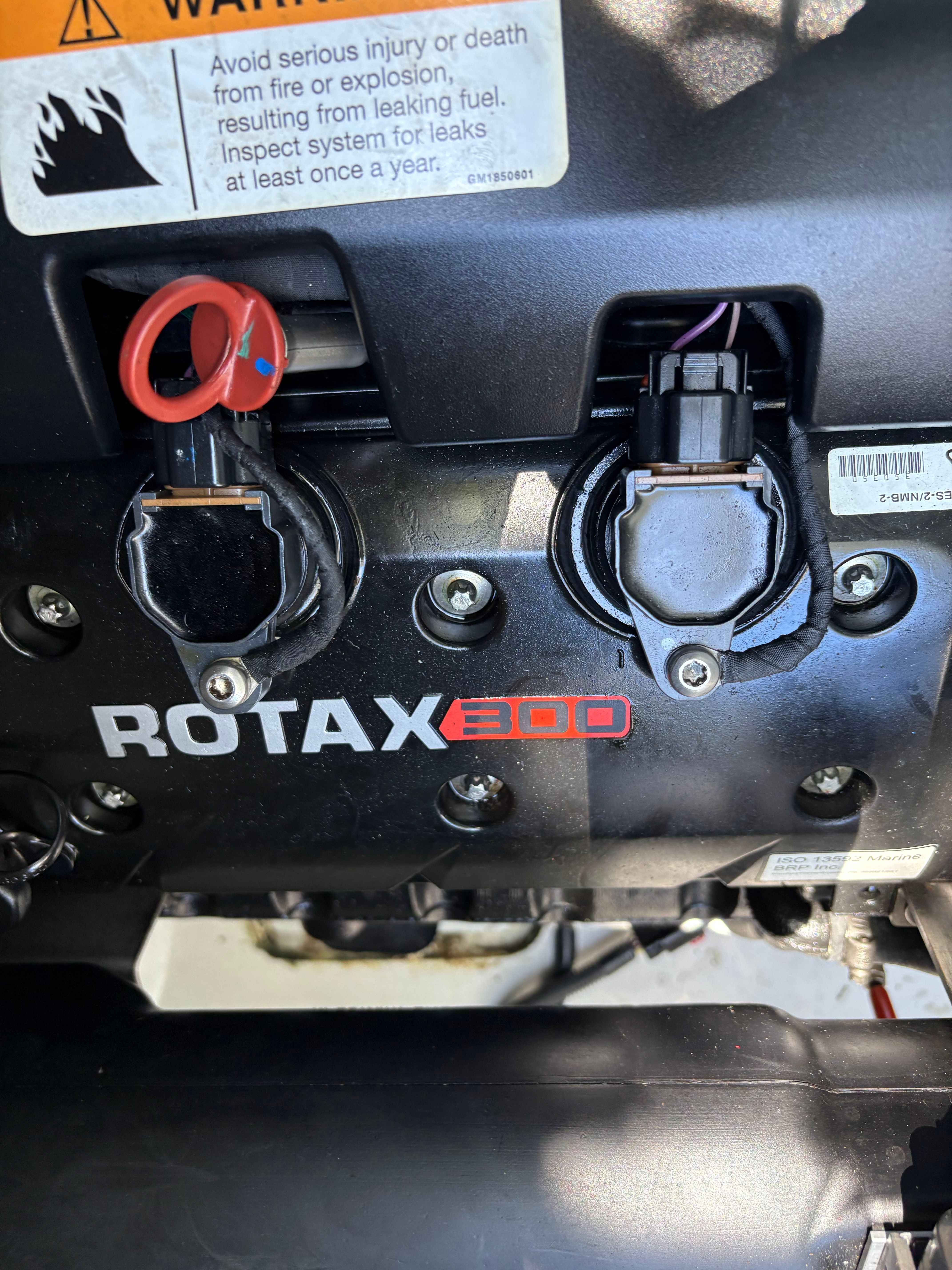 Close-up of a Rotax 300 engine with warning labels.