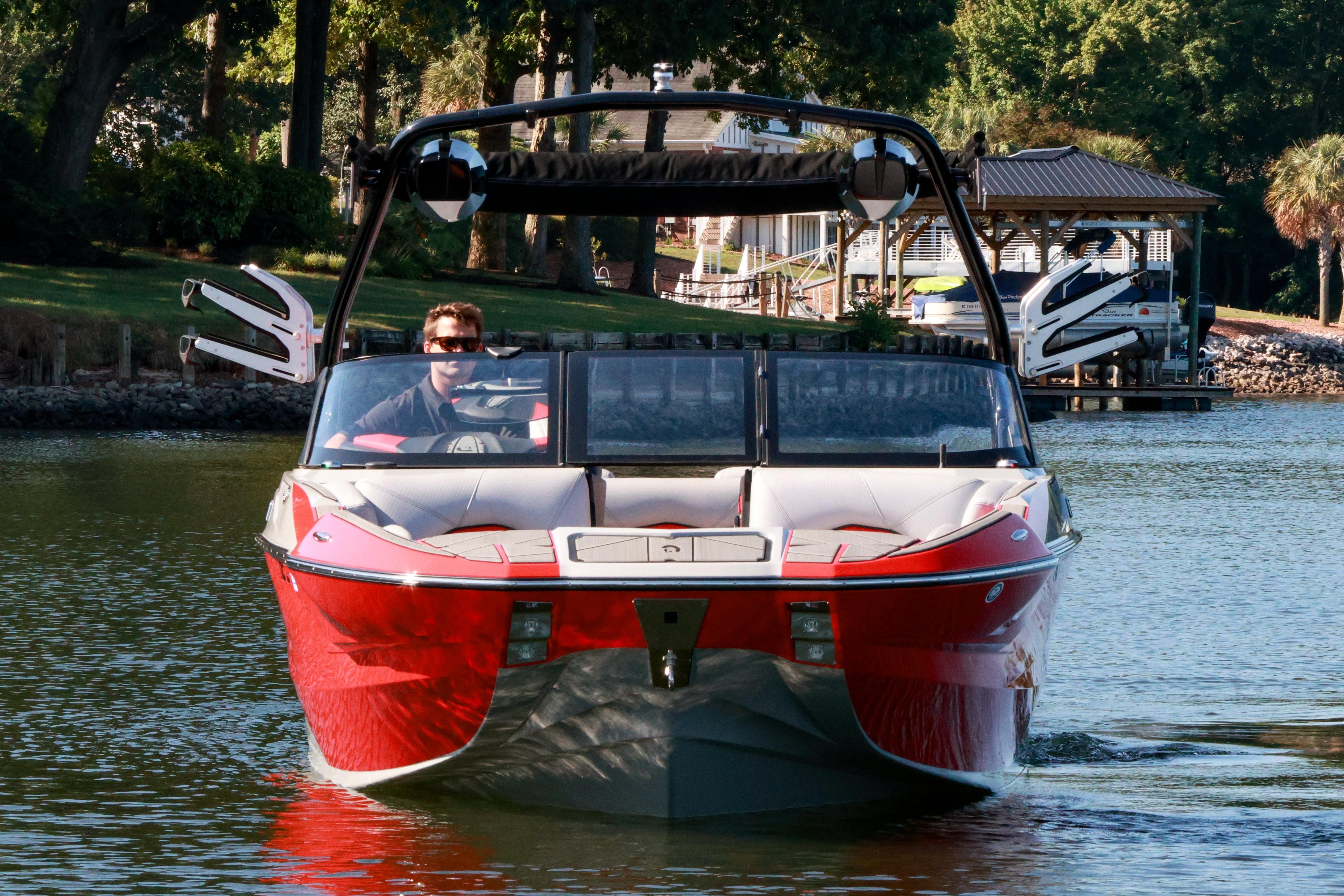 2024 Centurion Fi23 boat cruising on a serene lake with lush greenery.