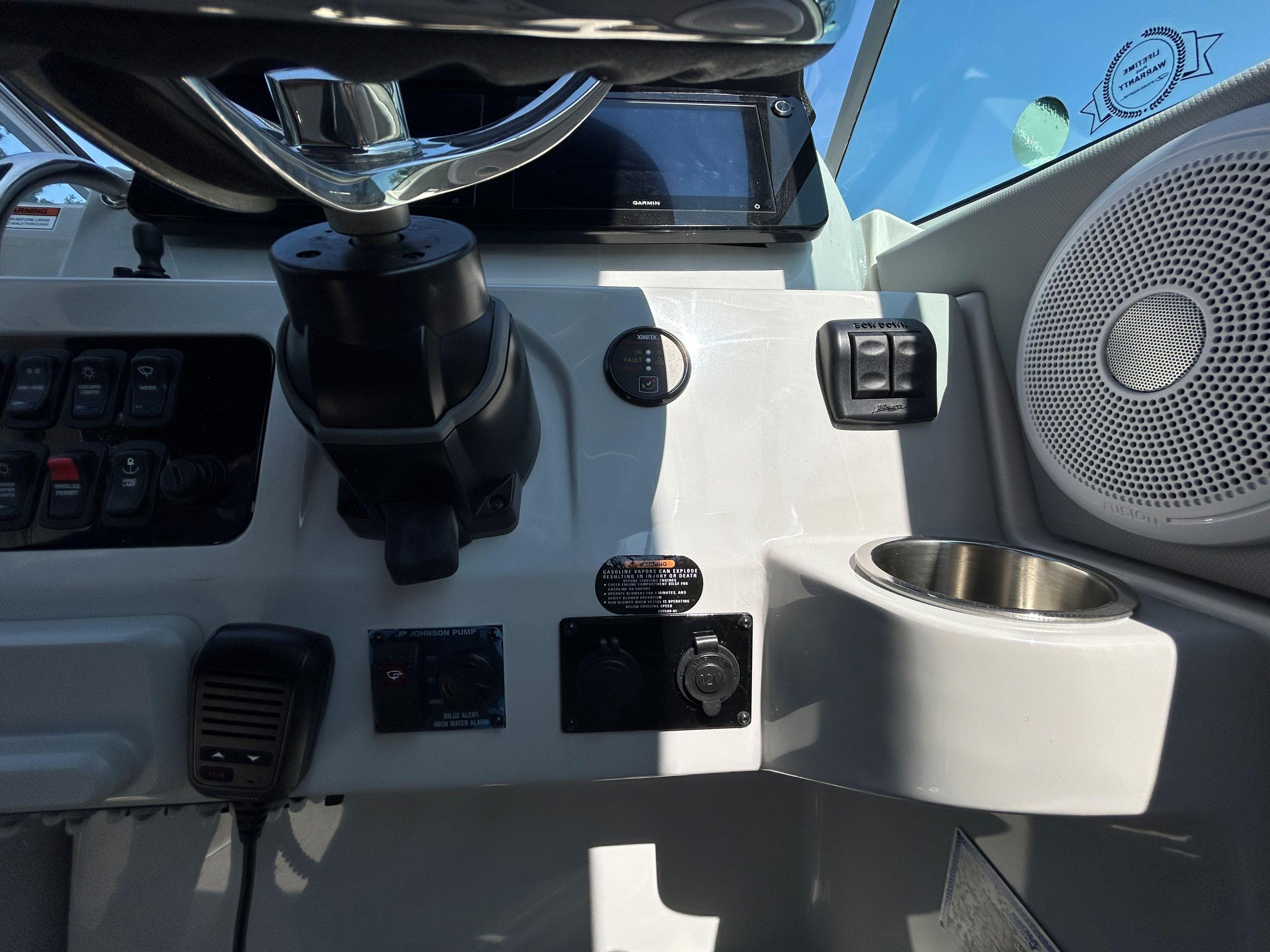 Control panel of 2025 Regal 26 XO boat with steering wheel and speaker.