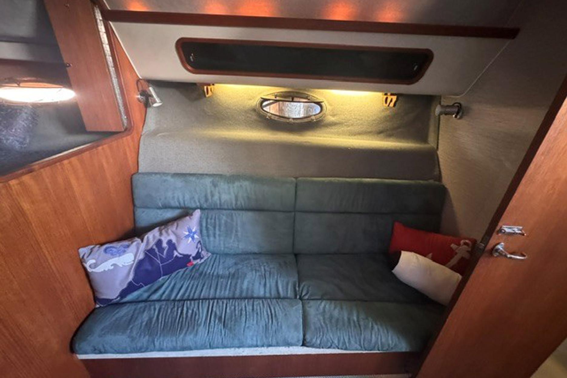 Cozy cabin interior of 1988 Tiara Yachts 3300 Open with plush seating and decorative pillows.