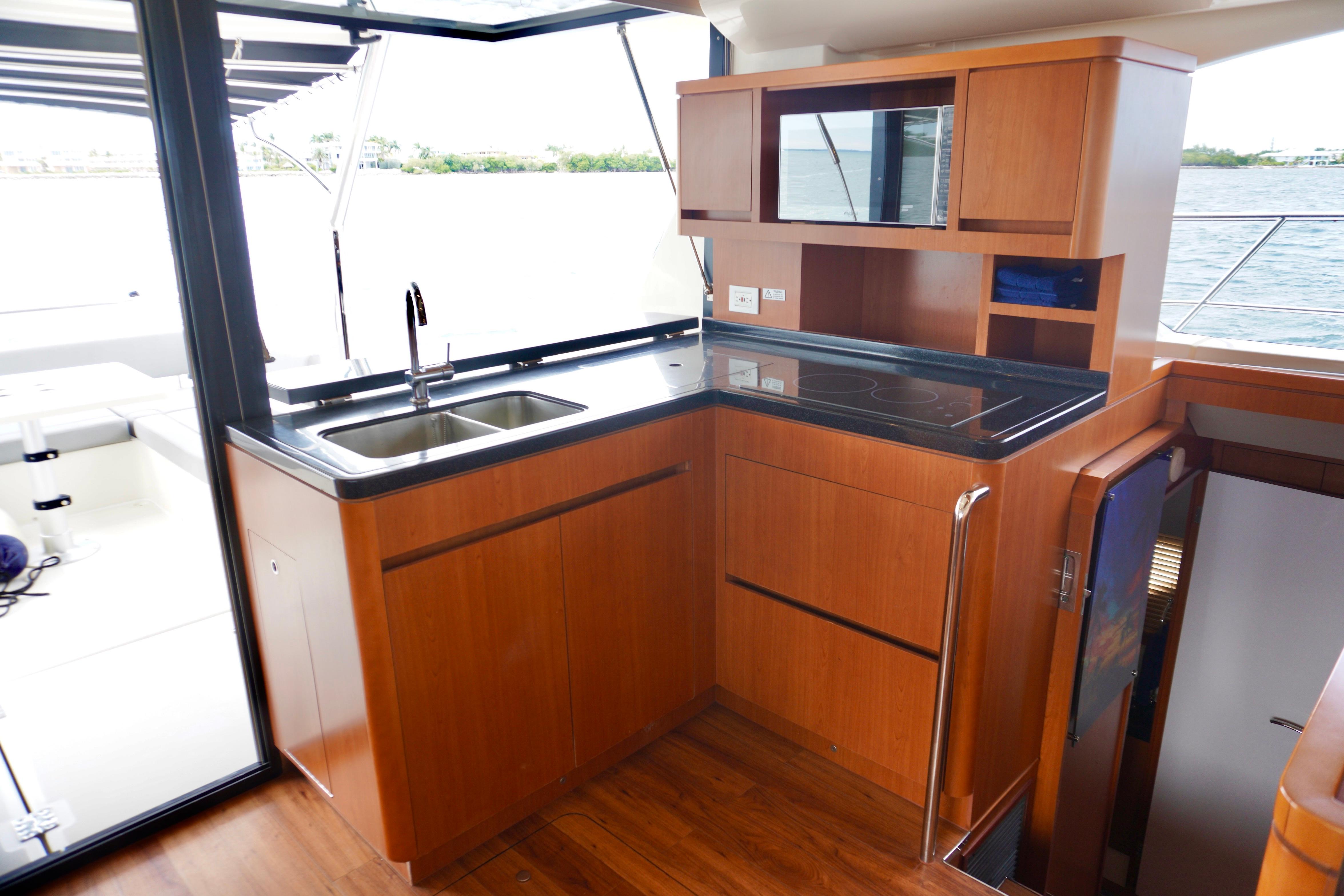 Luxurious kitchen interior of 2017 Aquila 44 Yacht with wooden cabinetry and modern appliances.