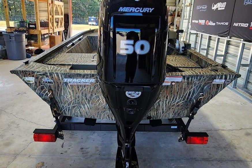 2026 Tracker Grizzly 1648 SC boat with Mercury 50 engine in a garage setting.