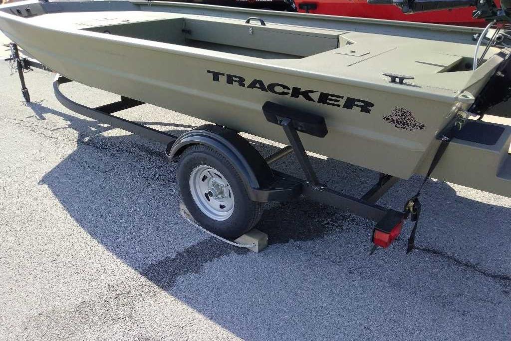 2026 Tracker Grizzly 1654 T Sportsman boat on trailer, parked on asphalt.