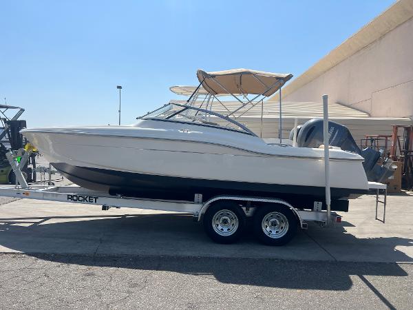 2019 Scout 210 Dorado boat on a Rocket trailer, parked outdoors.