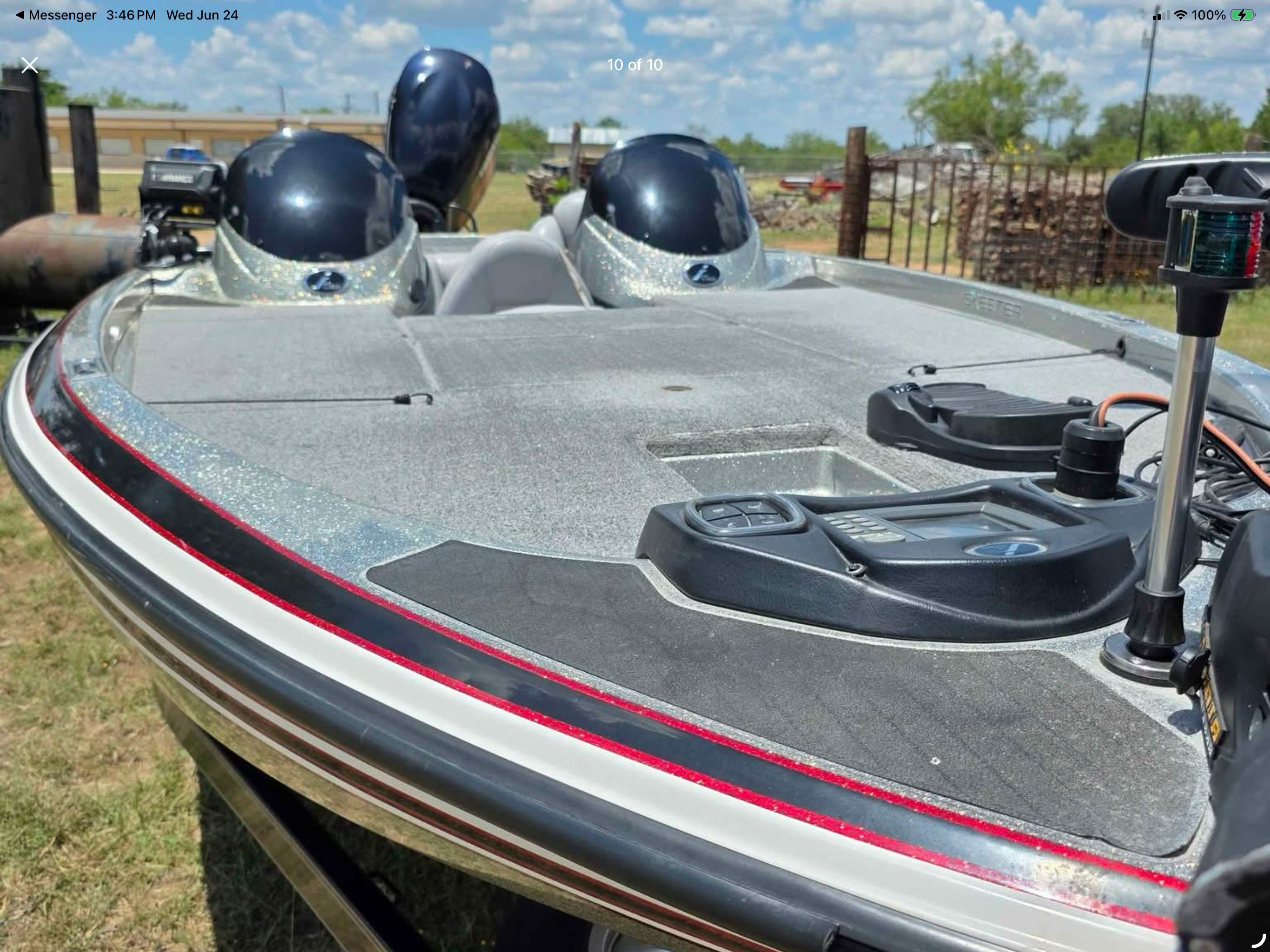 A 2006 Skeeter 20i boat with two outboard motors, parked on a trailer on land.