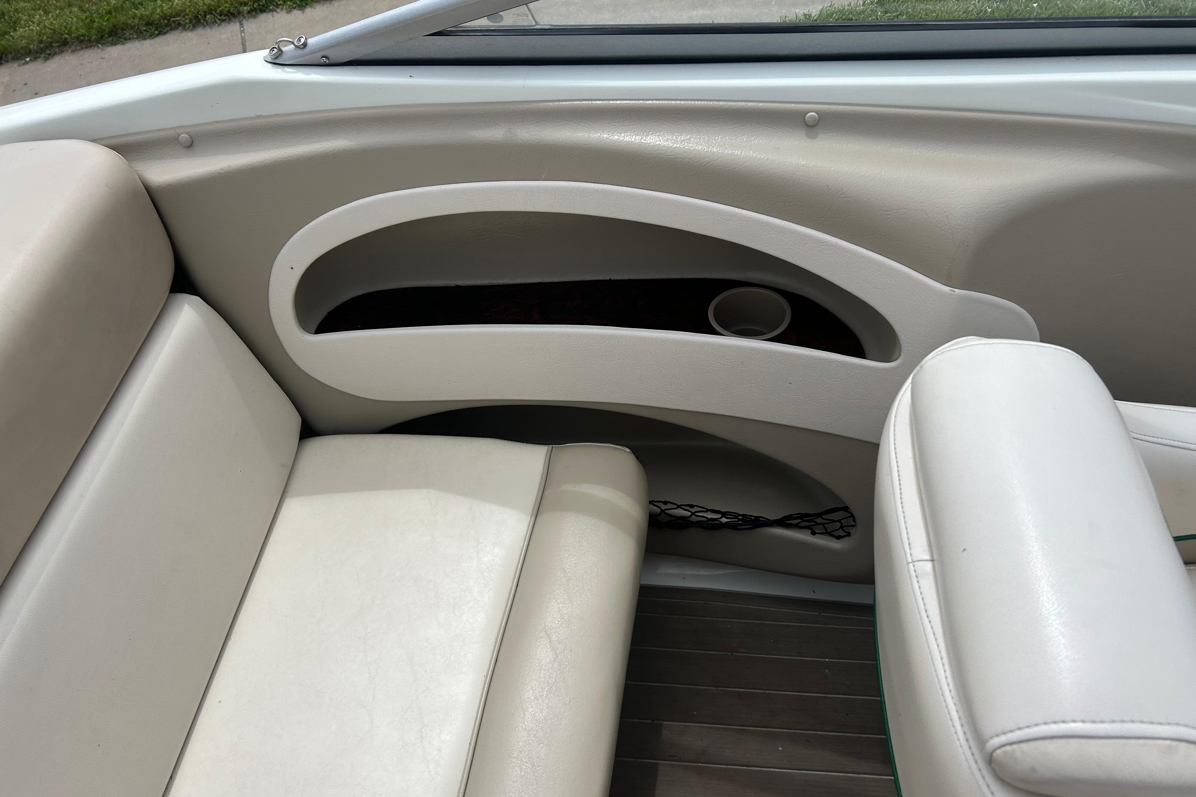 Interior seating of a 2000 Starcraft 1810 boat with cup holder and storage.