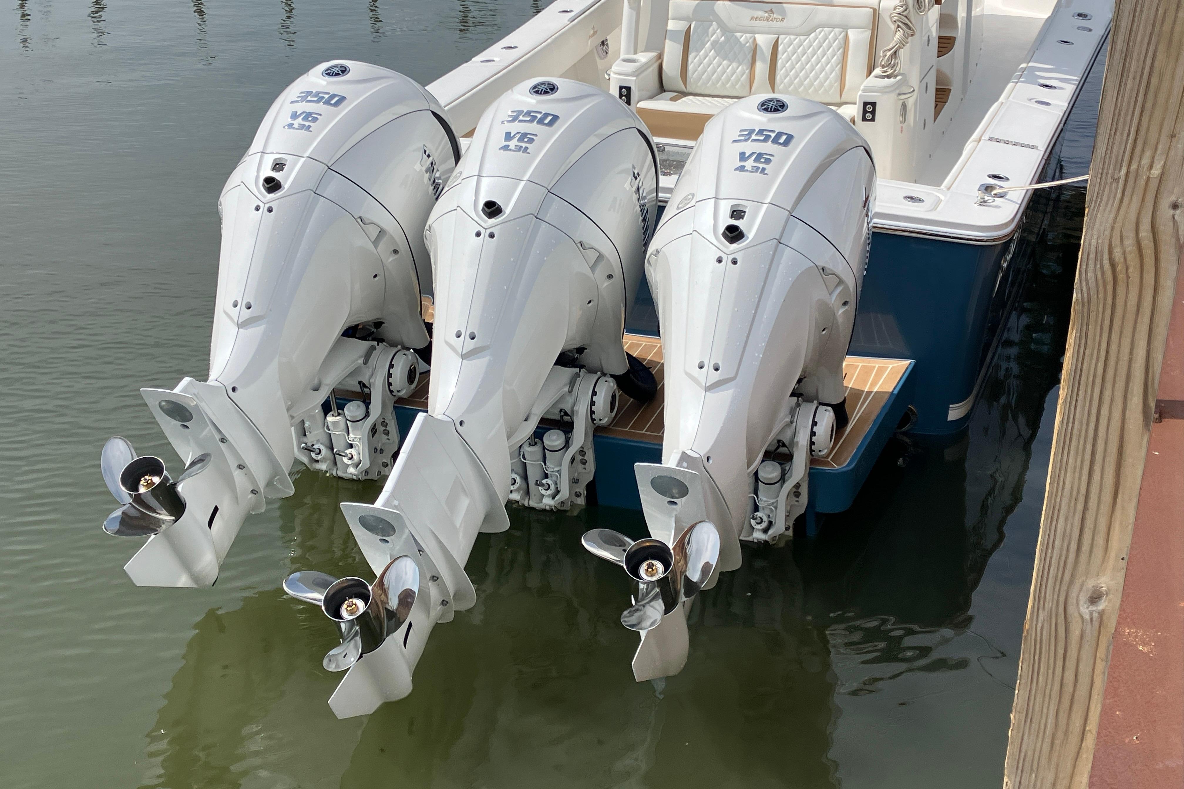 Triple Yamaha 350 V6 outboard engines on a 2027 Regulator 35 boat, docked in water.