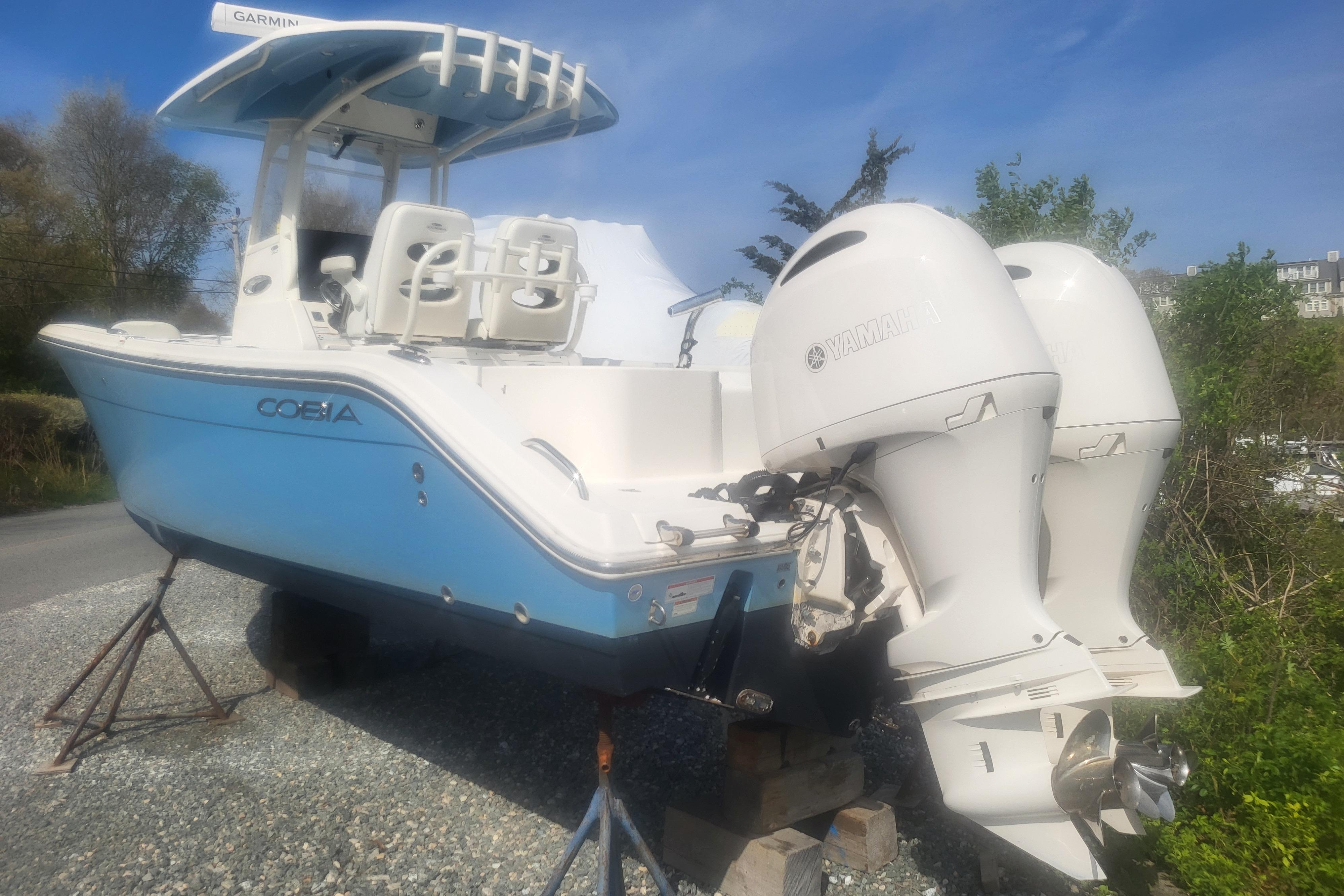 2022 Cobia 262 Center Console boat with twin Yamaha engines on a gravel lot.