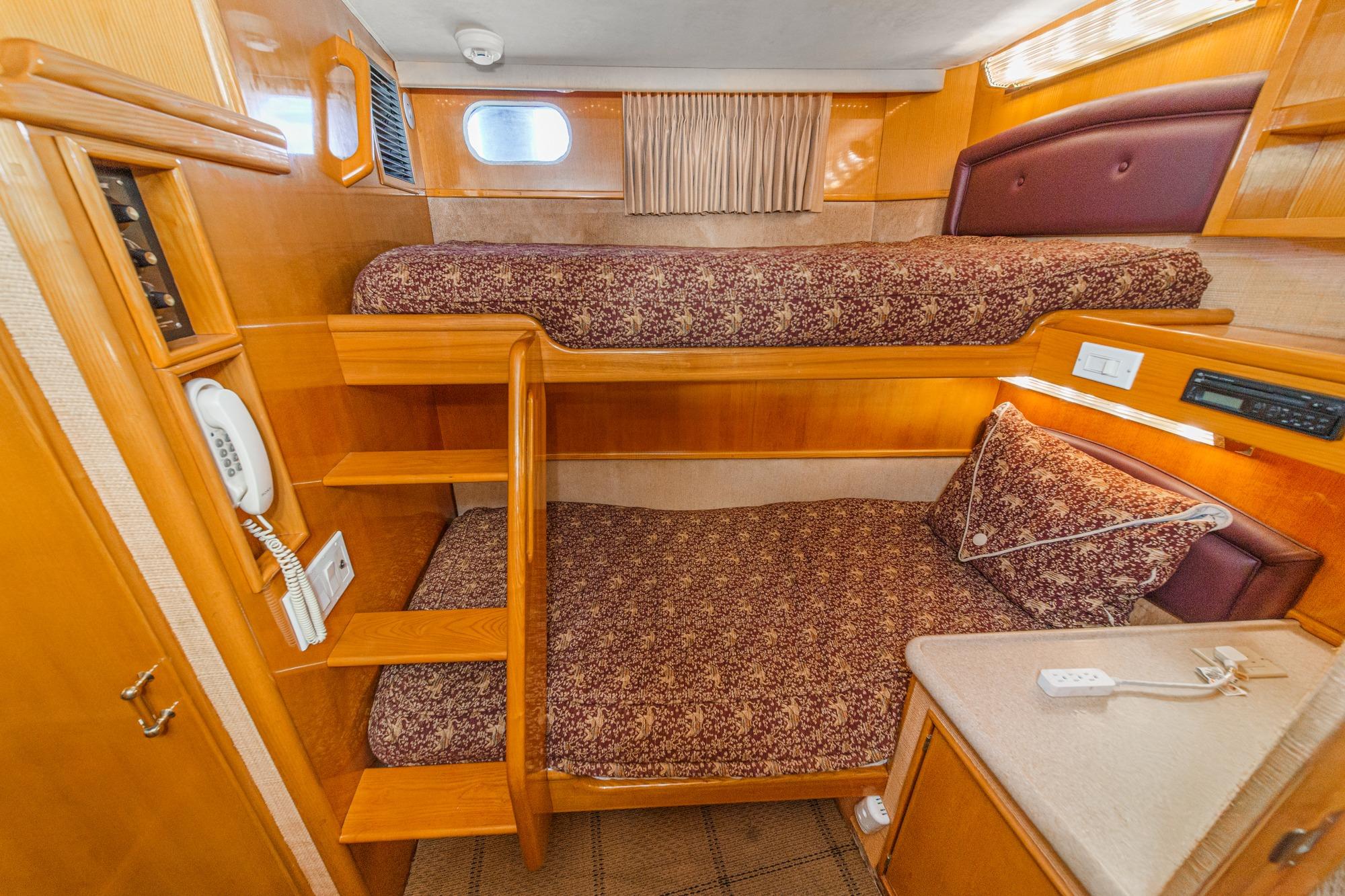 Interior of a 1990 Seaton Long Range Cruiser with cozy bunk beds and wooden furnishings.