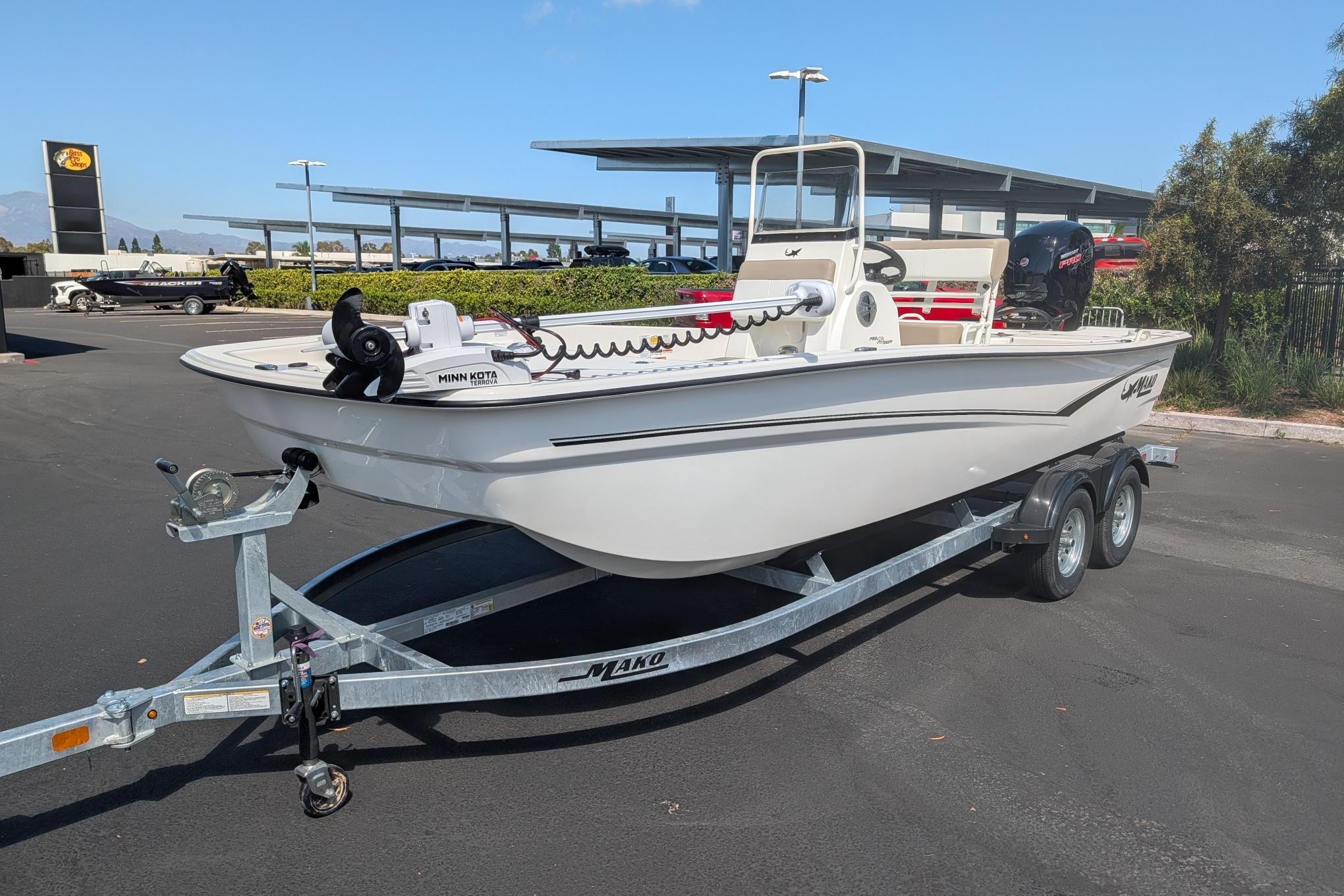 2026 Mako Pro Skiff 19 CC boat on trailer, parked outdoors under clear sky.