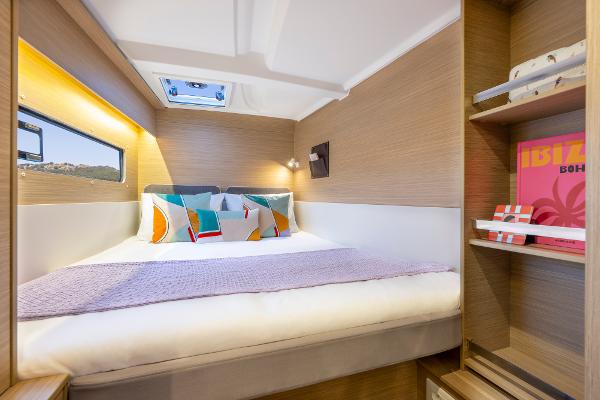 Cozy cabin interior of 2025 Lagoon 38 catamaran with modern decor and natural lighting.