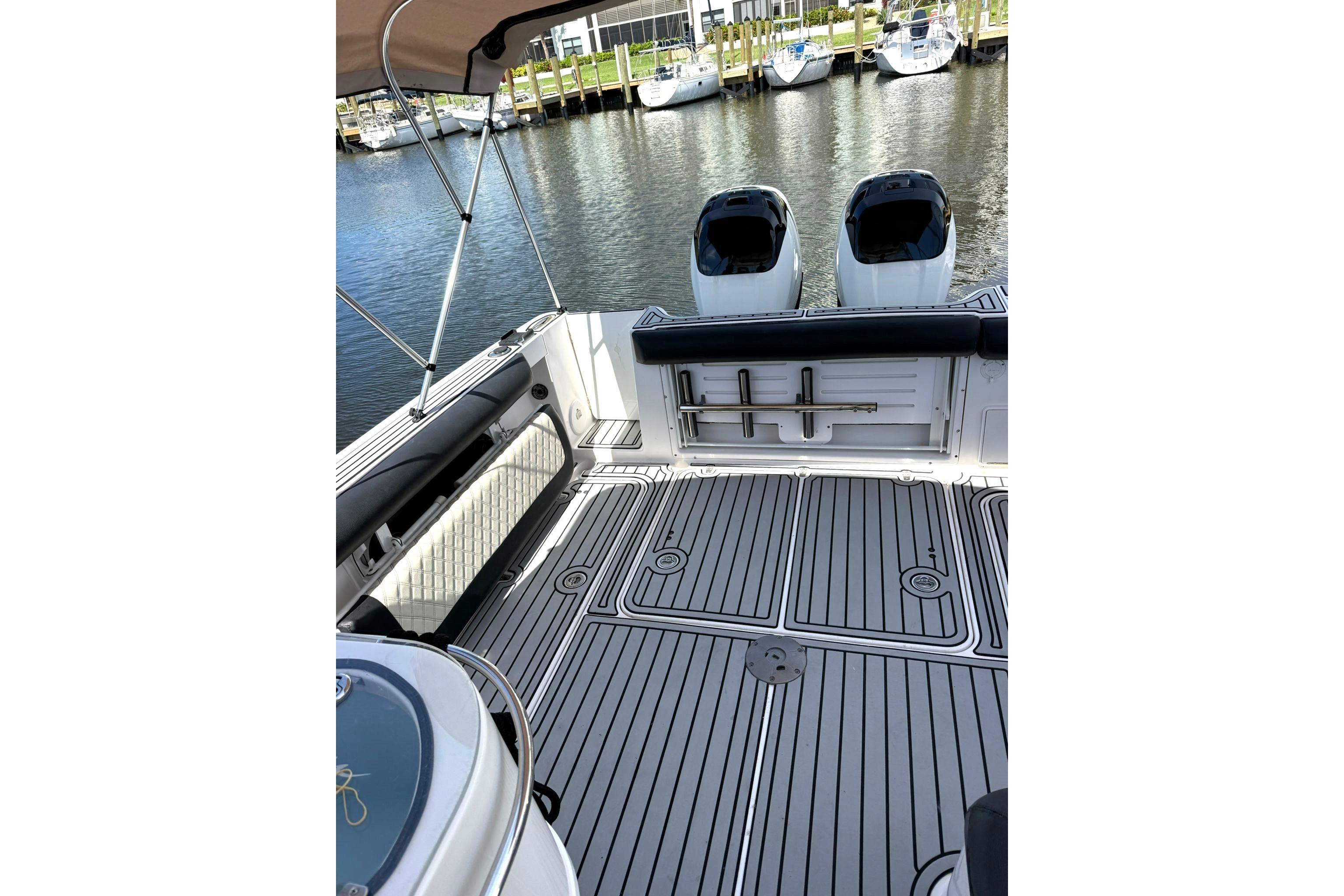 2006 Pro-Line 32 Express boat deck with twin engines, docked at marina.