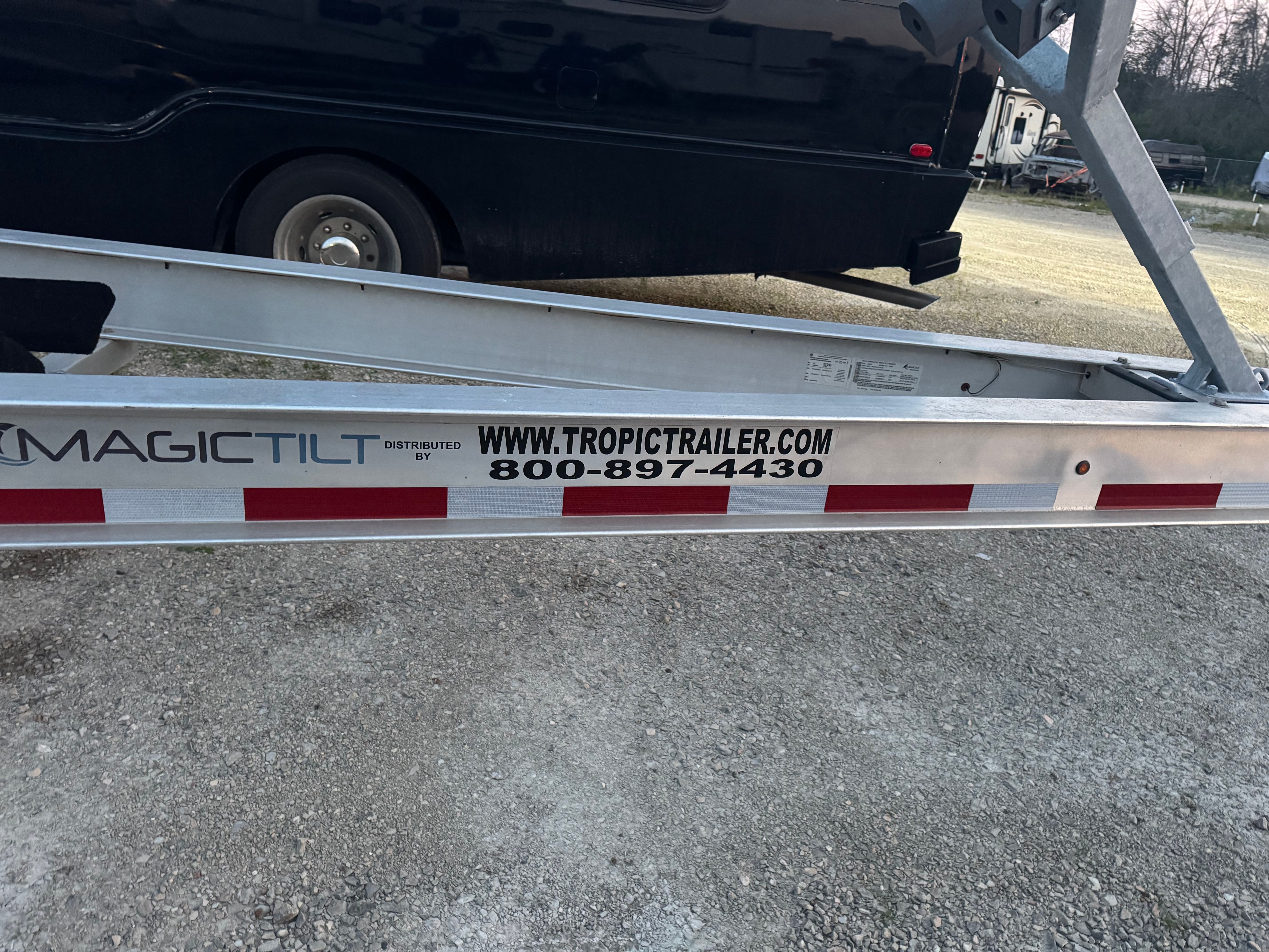 A boat trailer with "MAGICTILT" branding, featuring a website and phone number.