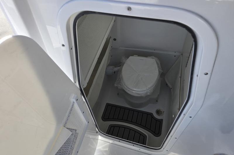Interior of 2026 Sea Hunt Ultra 275 Coffin Box boat, featuring a compact marine toilet.