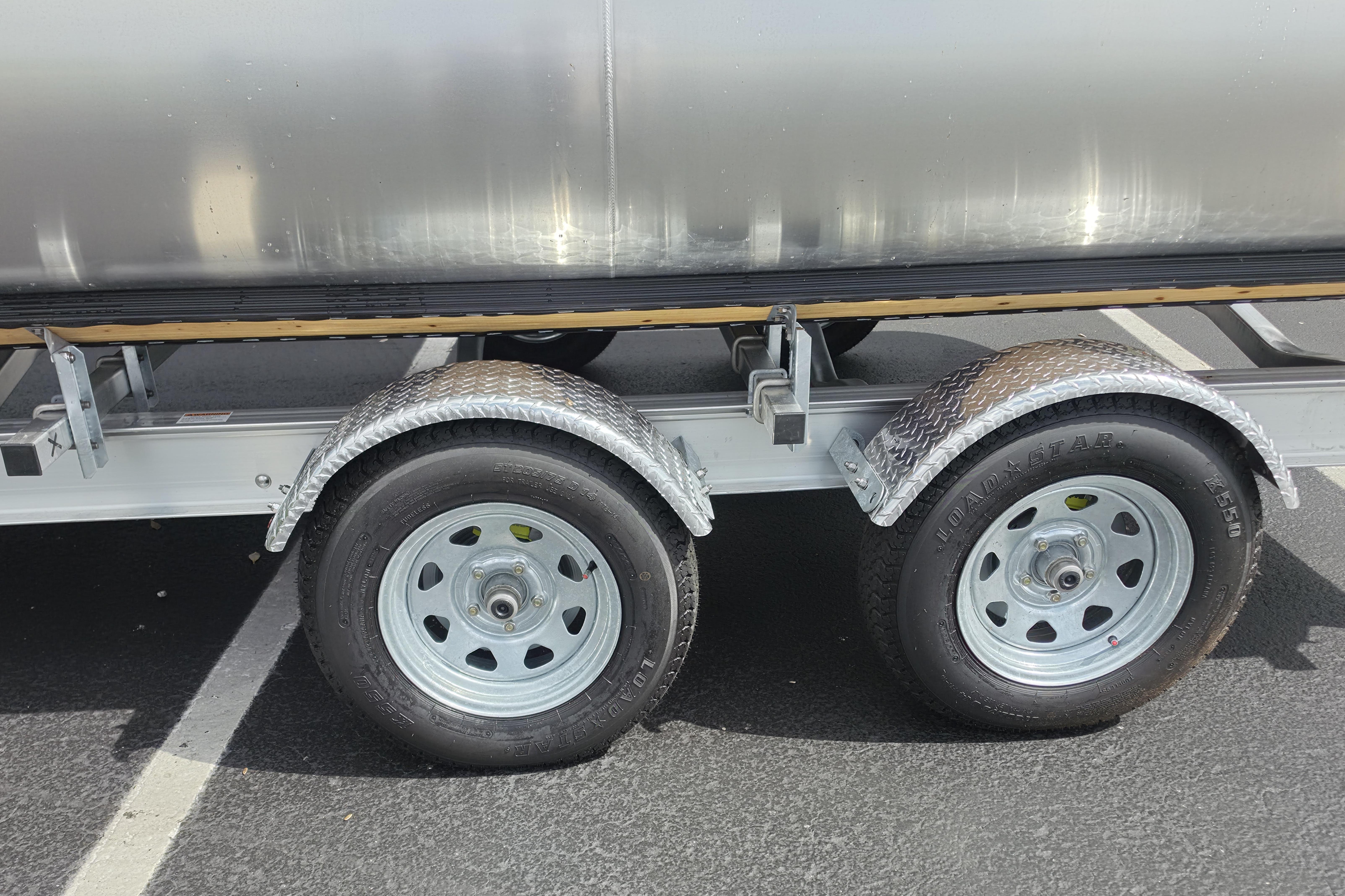 Trailer wheels of a 2026 Sun Tracker Party Barge 24 XP3 pontoon boat.