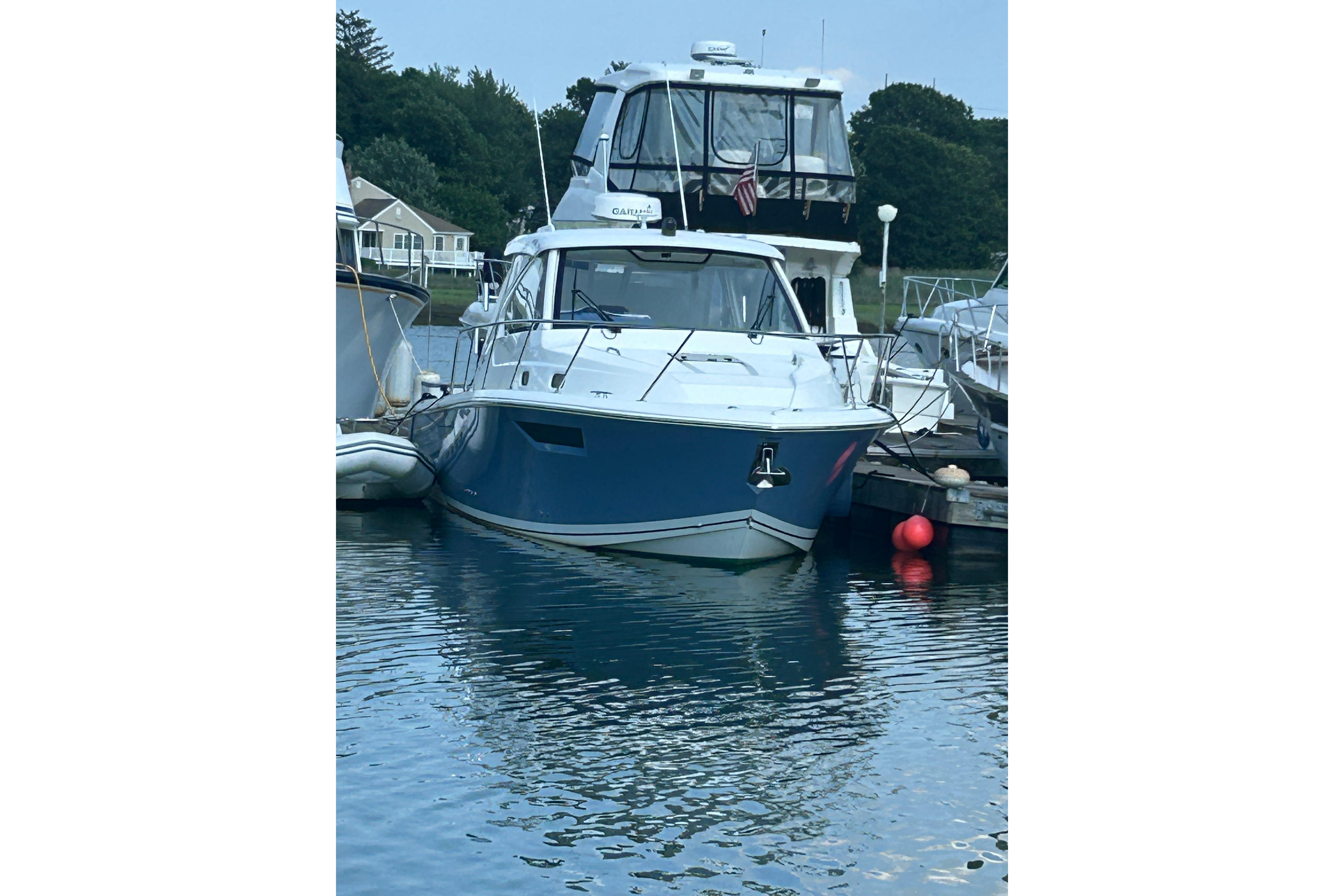2021 Pursuit OS 325 Offshore boat docked in a serene marina setting.