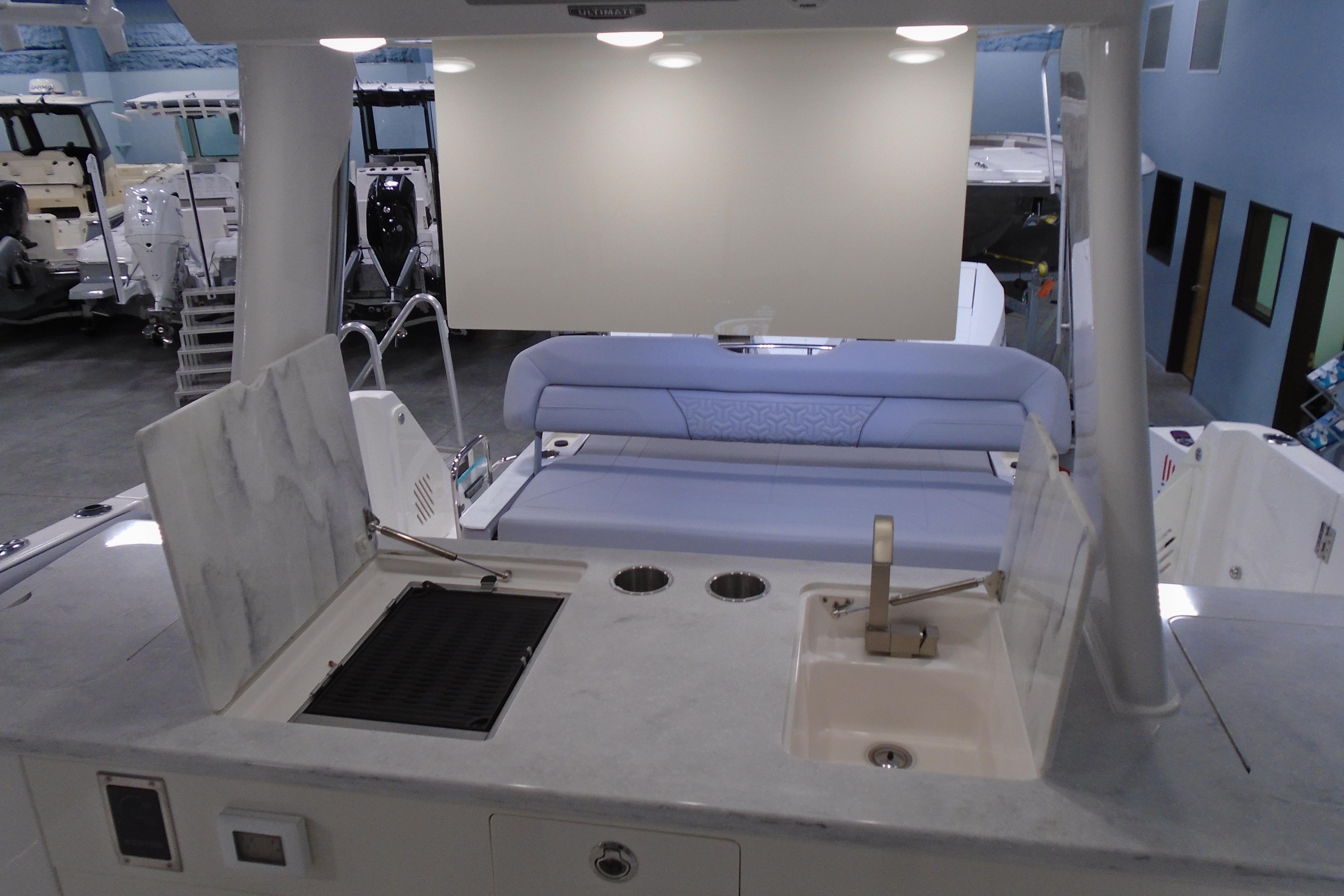 2026 Regal 38 SAV boat interior with kitchenette and seating area in showroom.