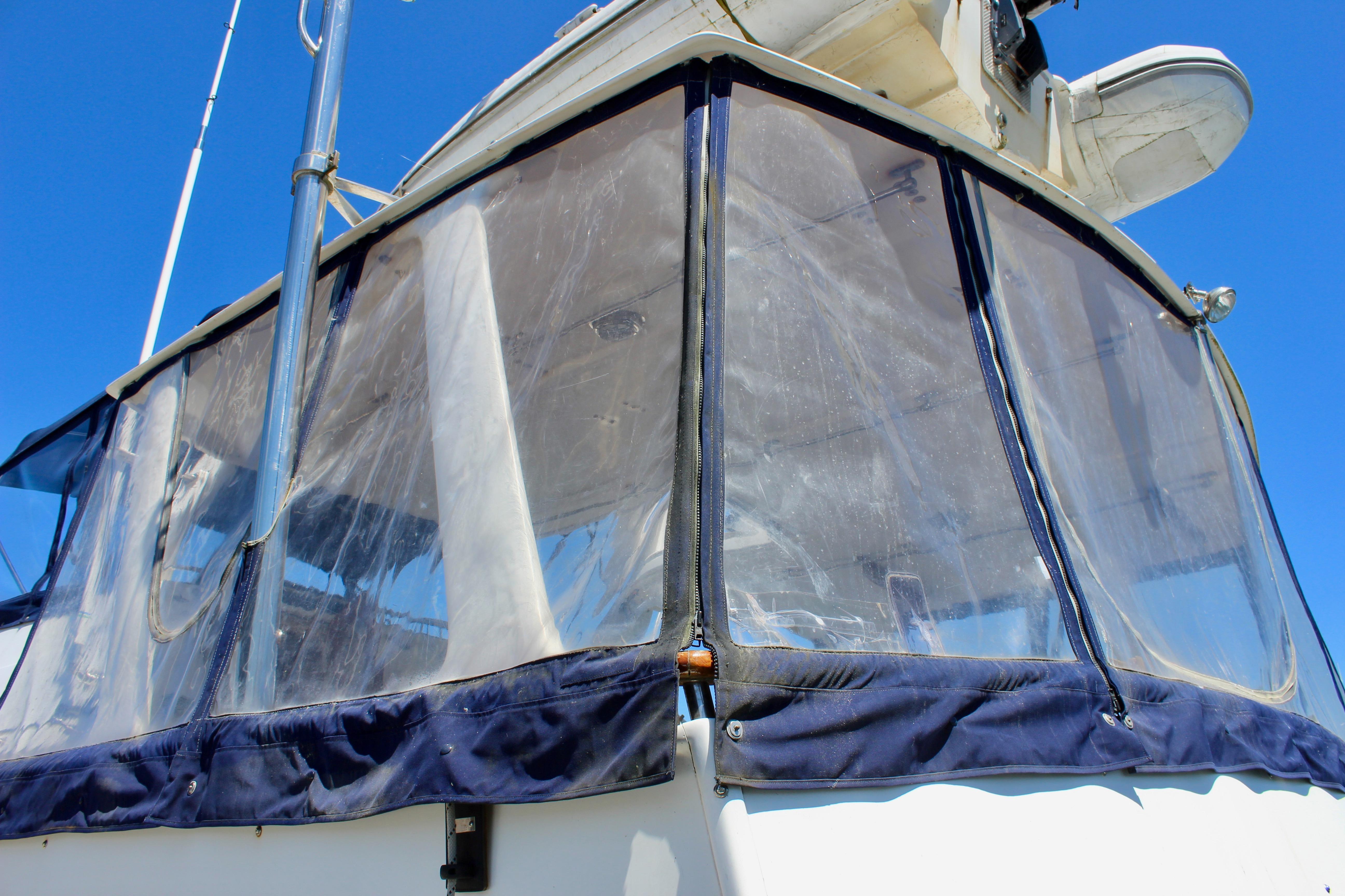 1986 Kha Shing Spindrift 46 yacht with clear enclosure against blue sky.