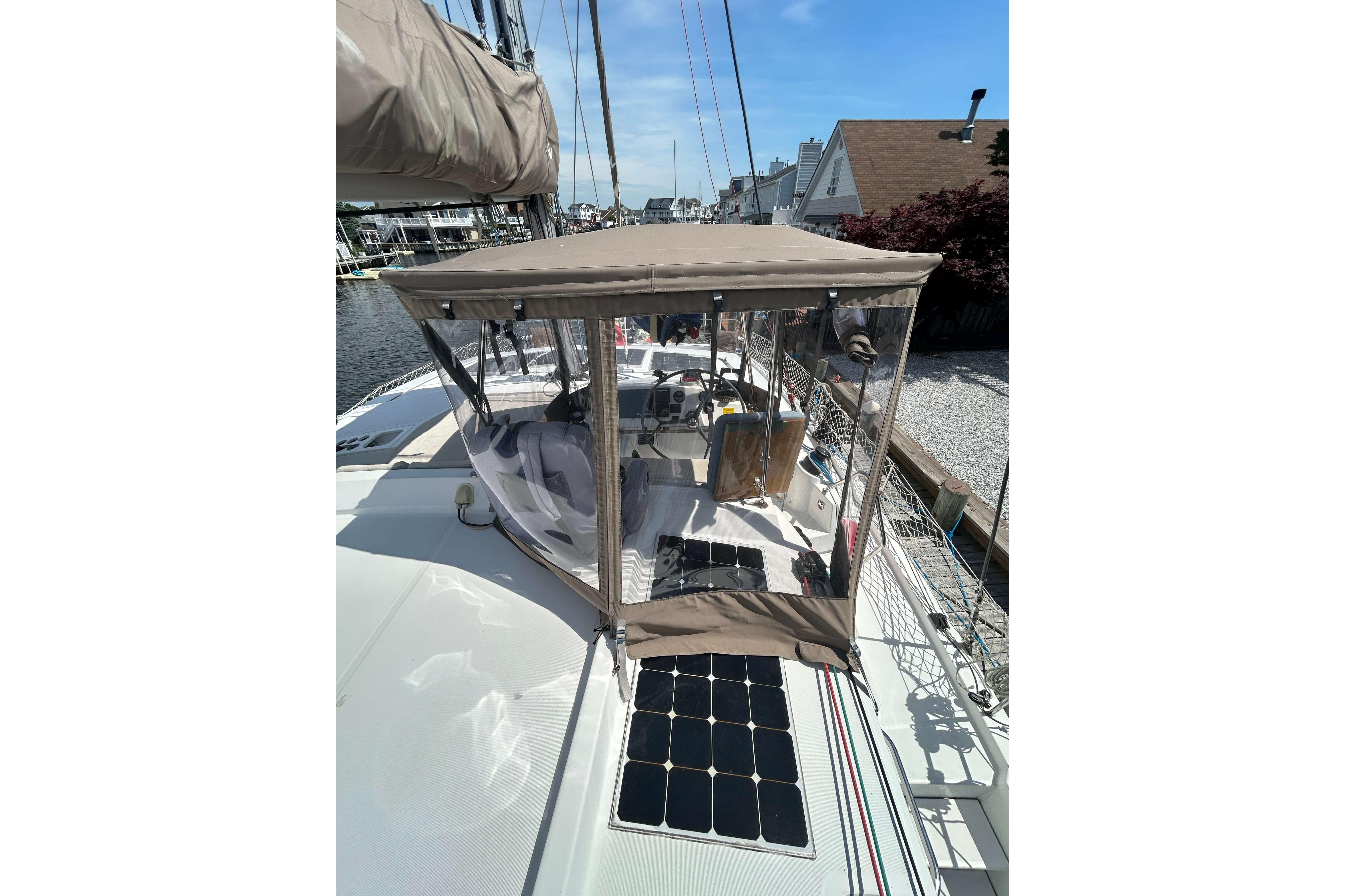2018 Bali 4.1 catamaran with solar panels and cockpit enclosure in a marina.