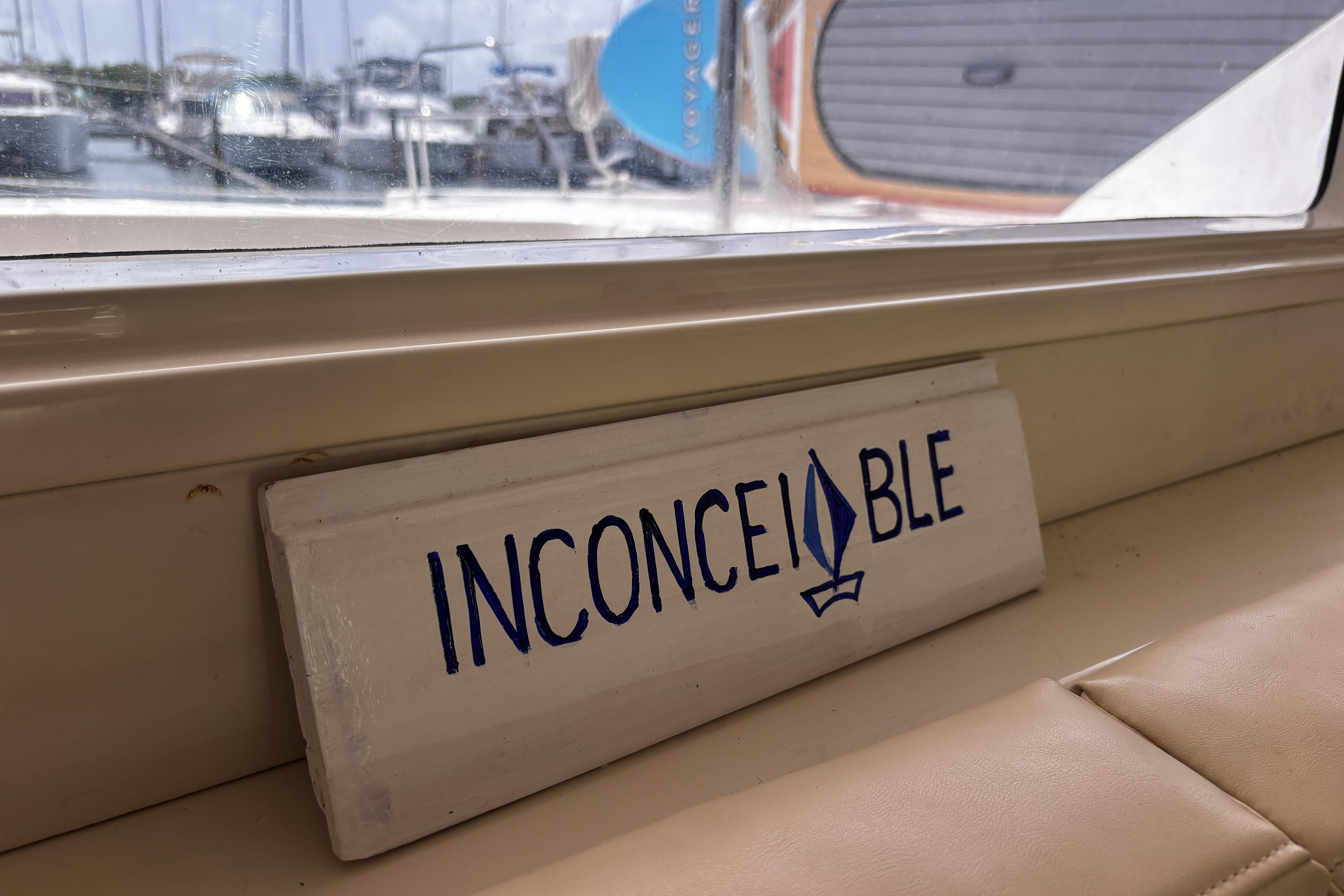Sign reading "INCONCEIVABLE" inside a 2012 Leopard 44 yacht, with marina view.