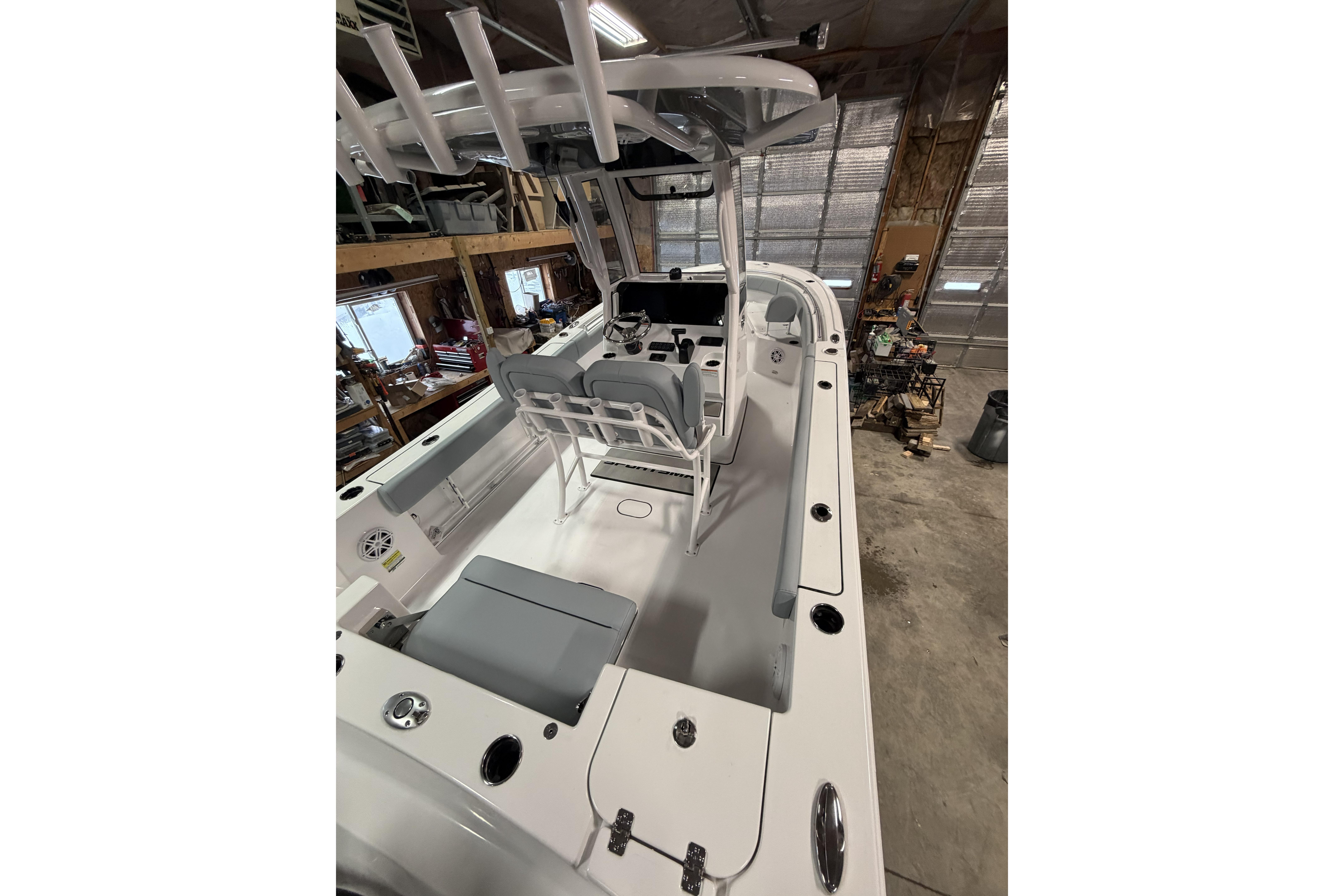 2026 Sportsman Open 232 Center Console boat in a garage, showcasing interior layout.