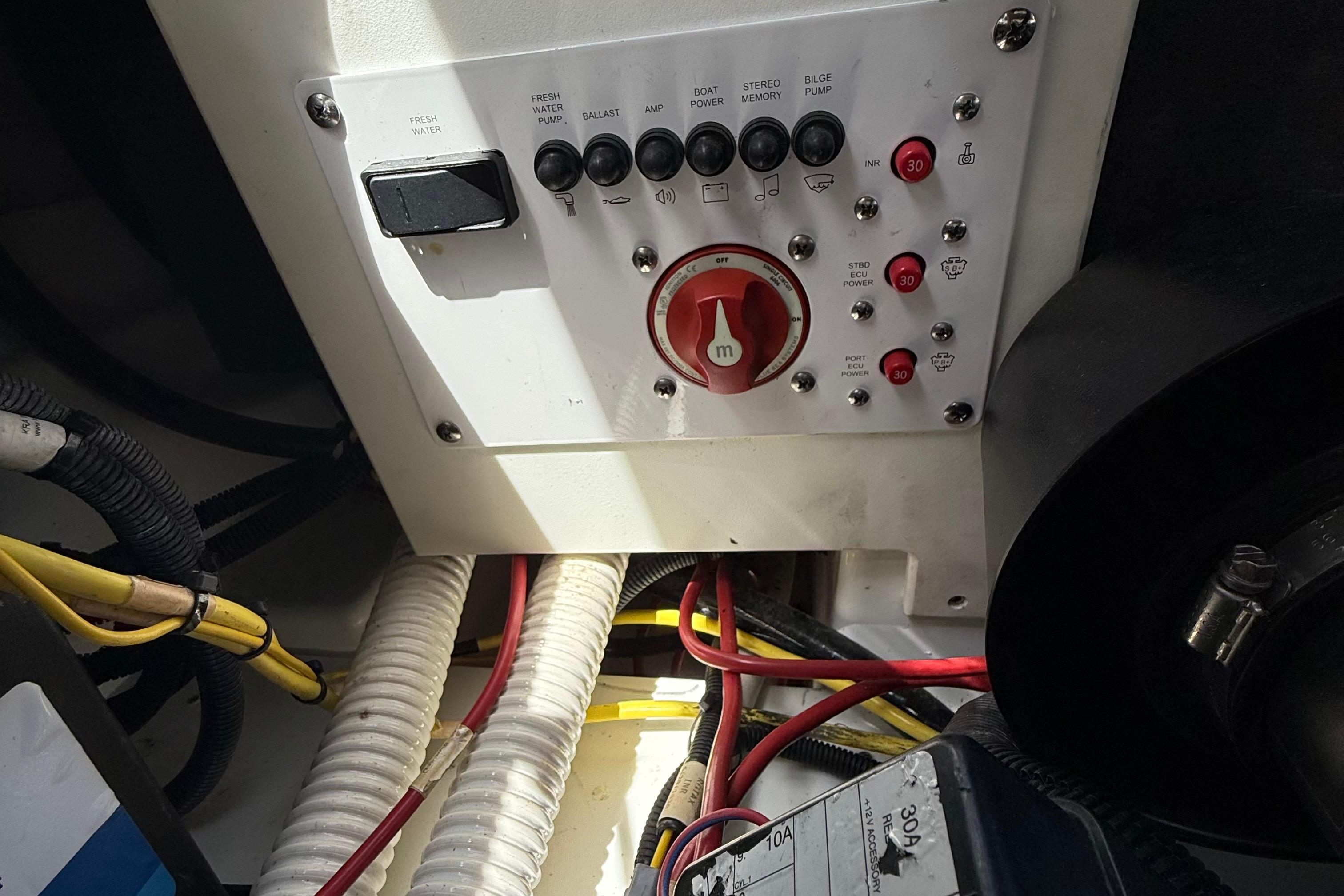 Control panel of a 2021 Scarab 255 Open ID boat with wiring and switches.