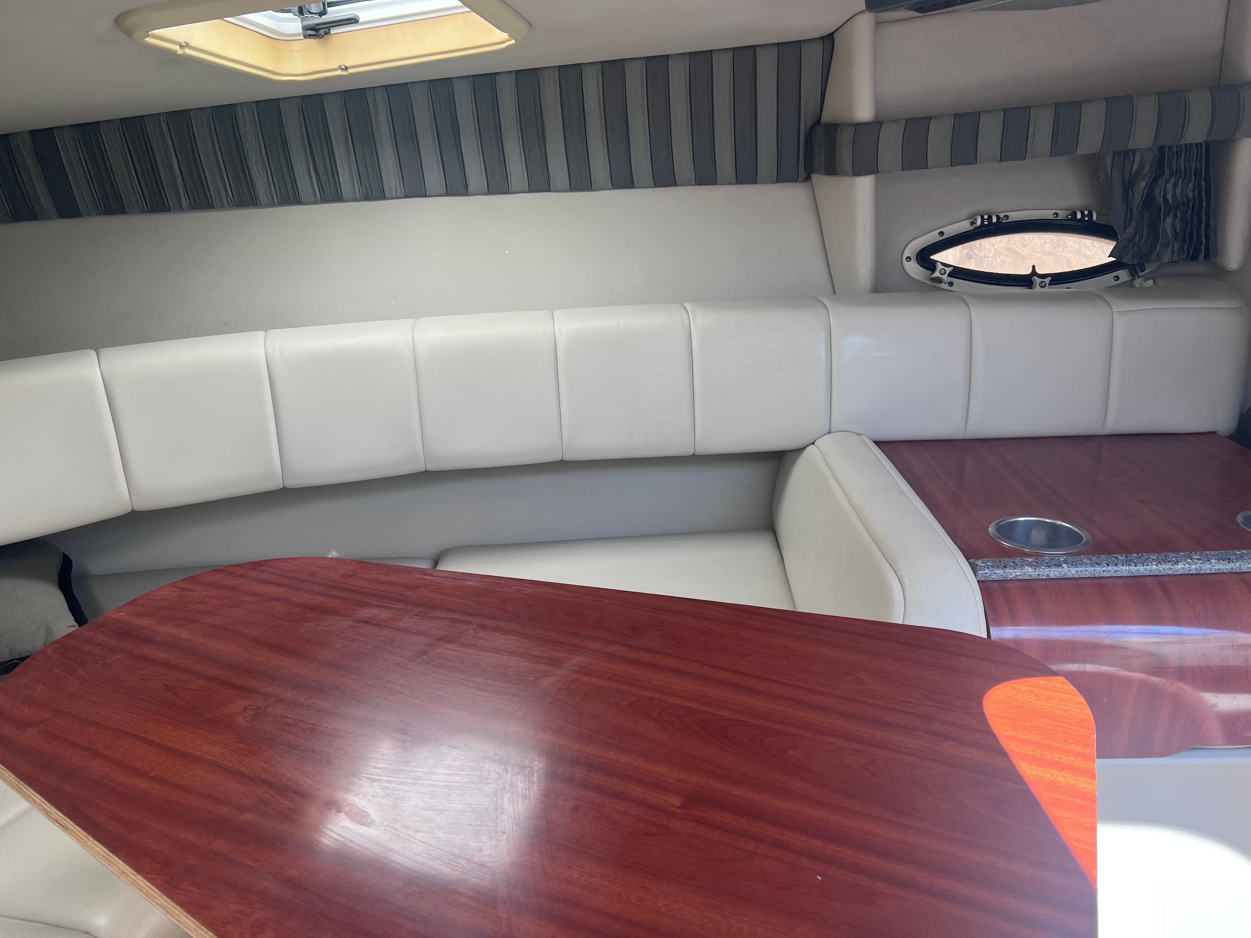 Interior of 2006 Formula 260 Sun Sport with wood table and cushioned seating.