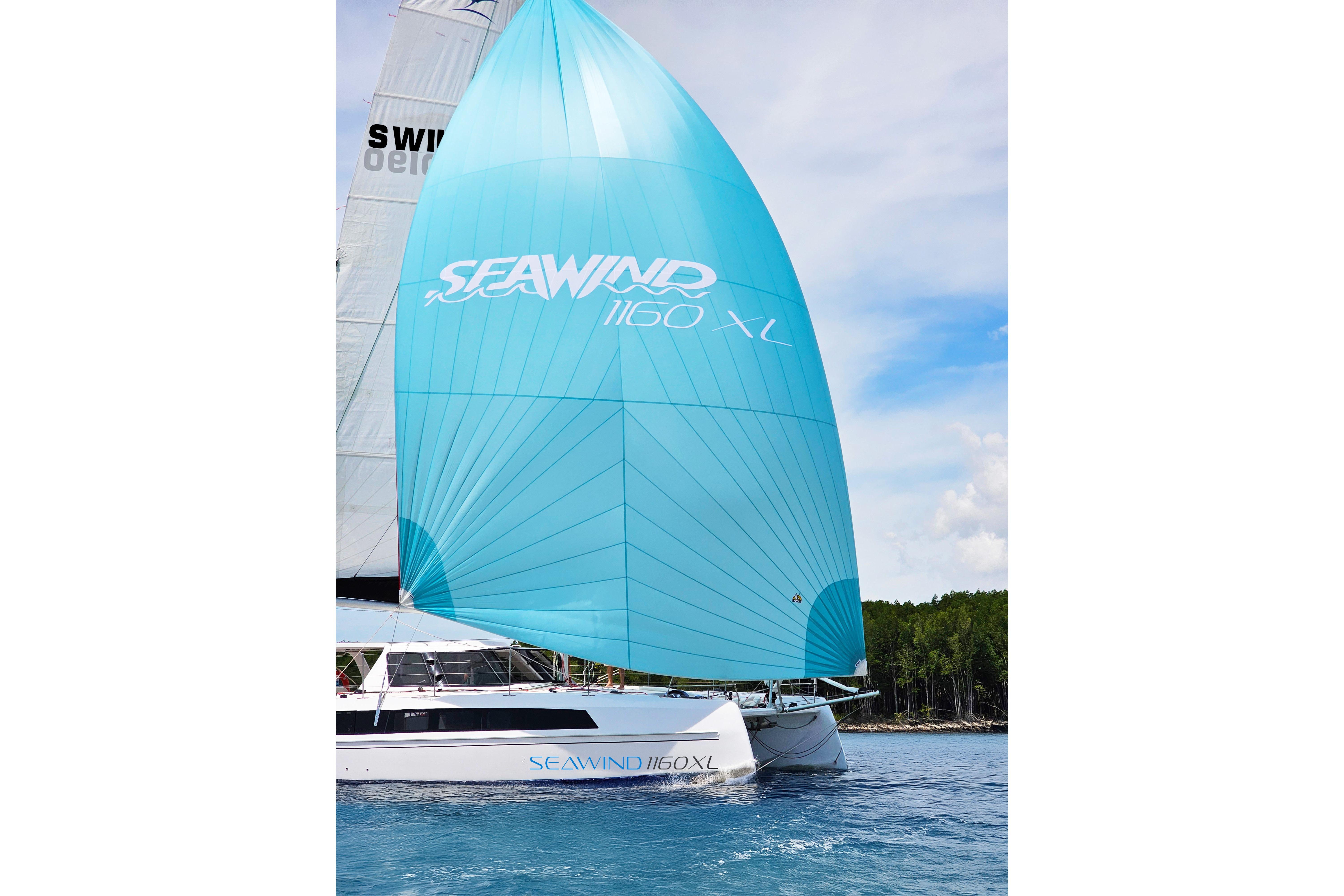 2026 Seawind 1160XL catamaran sailing with vibrant blue spinnaker on a clear day.