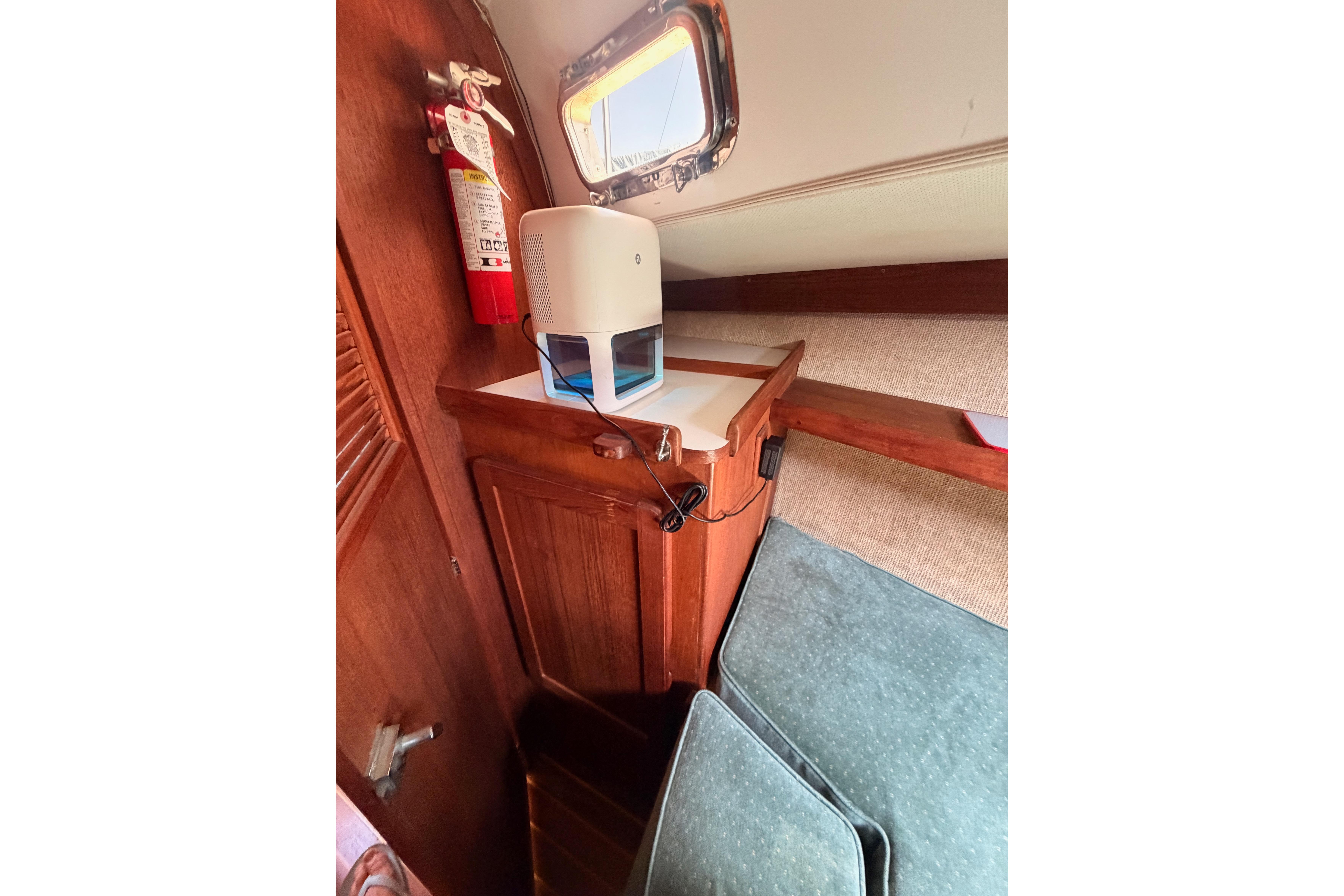 Cozy interior of 1991 Caliber 33 sailboat with wooden cabinetry and a fire extinguisher.