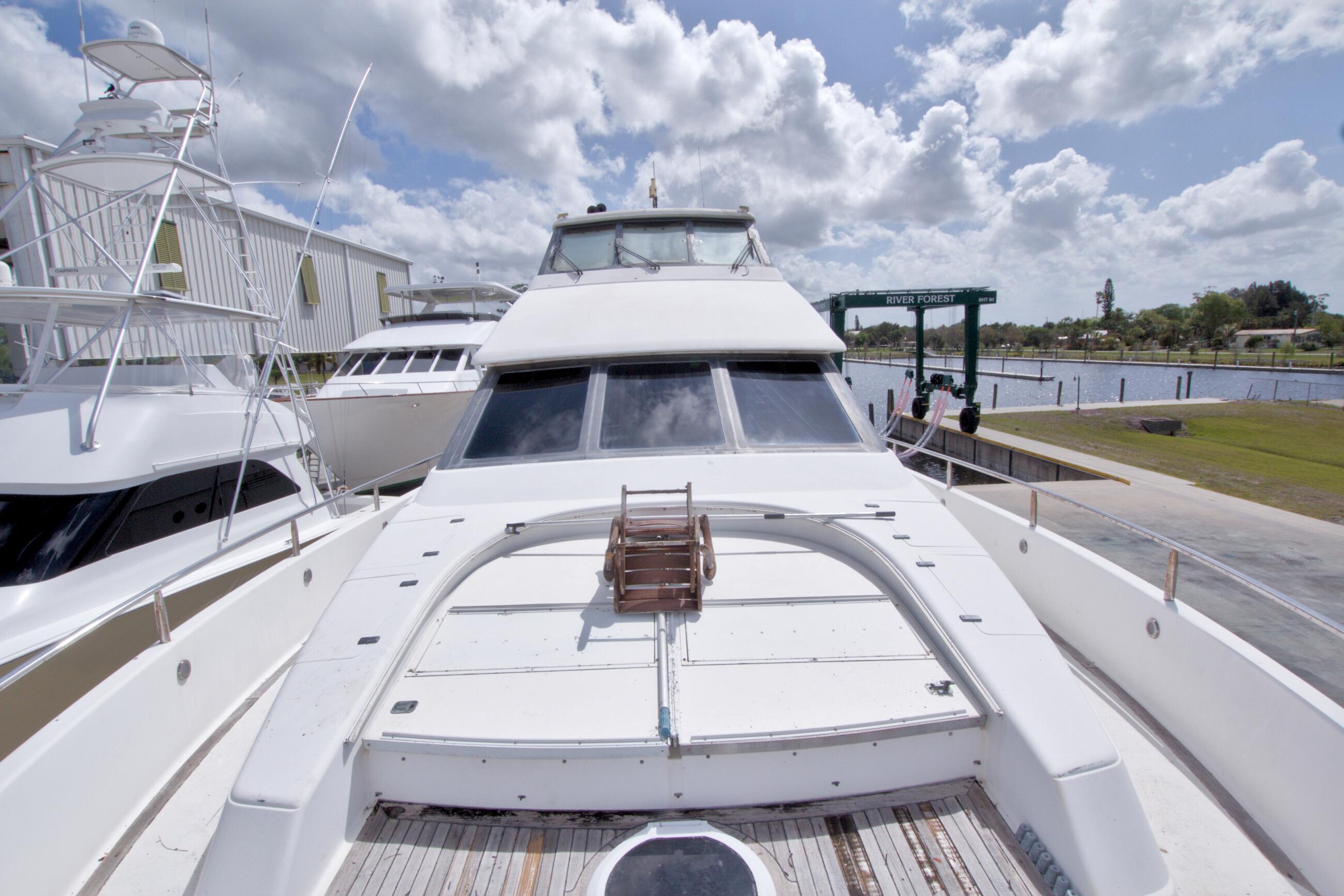 1998 Lazzara 76 Skylounge Grand Salon yacht docked under cloudy skies.