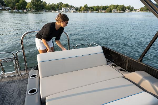 Manufacturer Provided Image: Woman on Qwest Splash Pad E-Class 2025 boat by the lake.