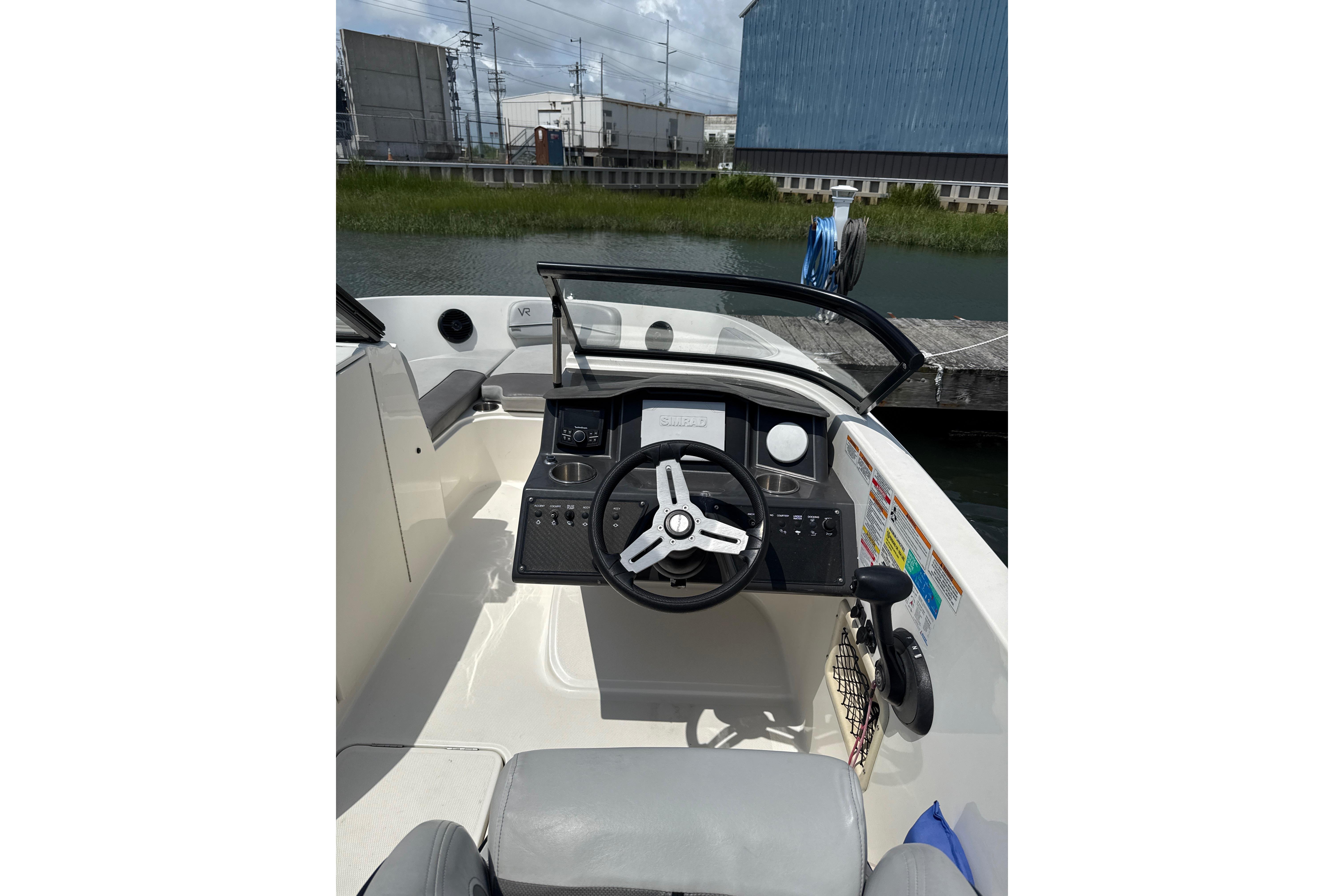 2023 Bayliner VR6 Bowrider OB cockpit with steering wheel and control panel.