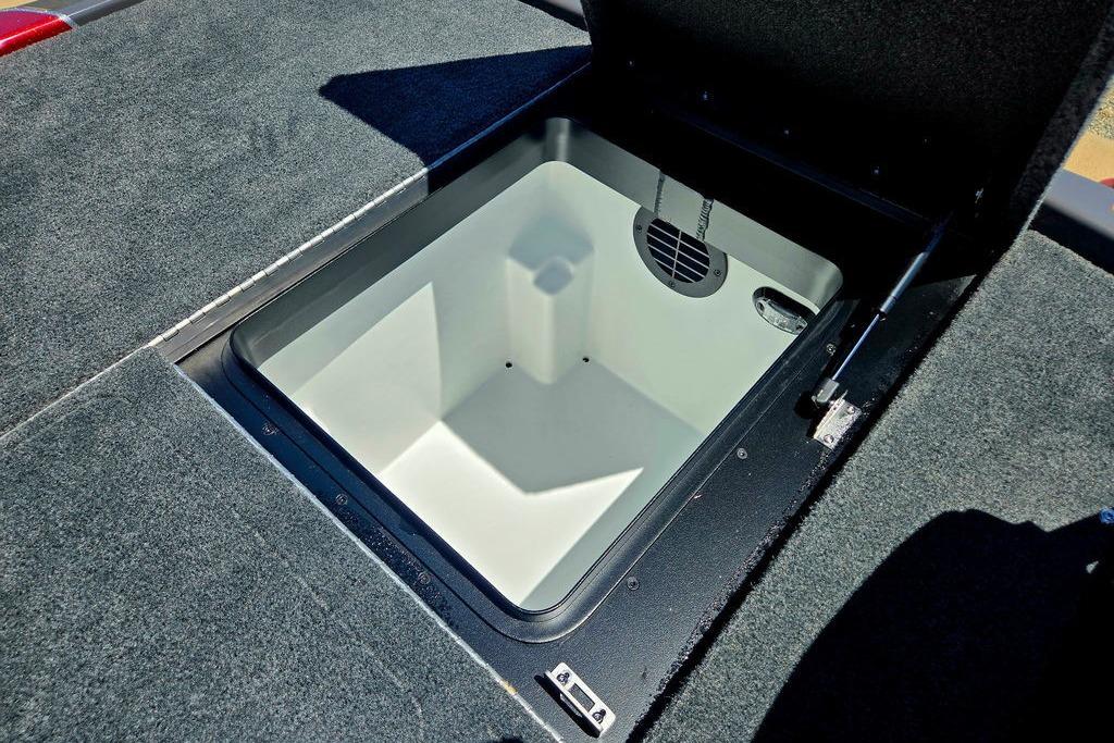 Open storage compartment in 2026 Skeeter ZXE20 boat, featuring carpeted interior and hydraulic lift.