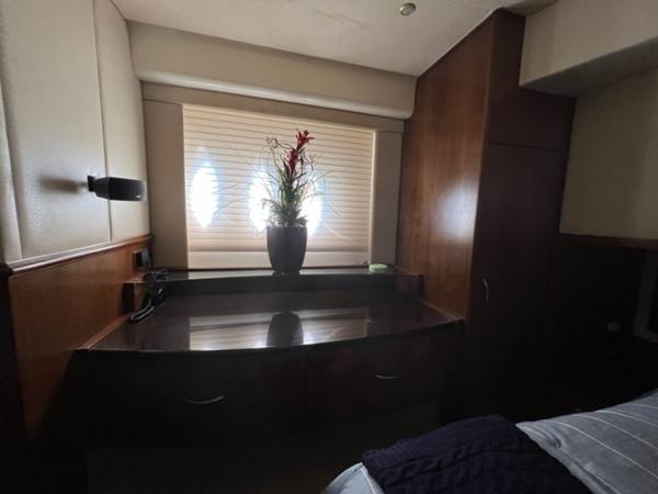 Luxurious interior of 2009 Ovation 52 yacht with wooden cabinetry and decorative plant.