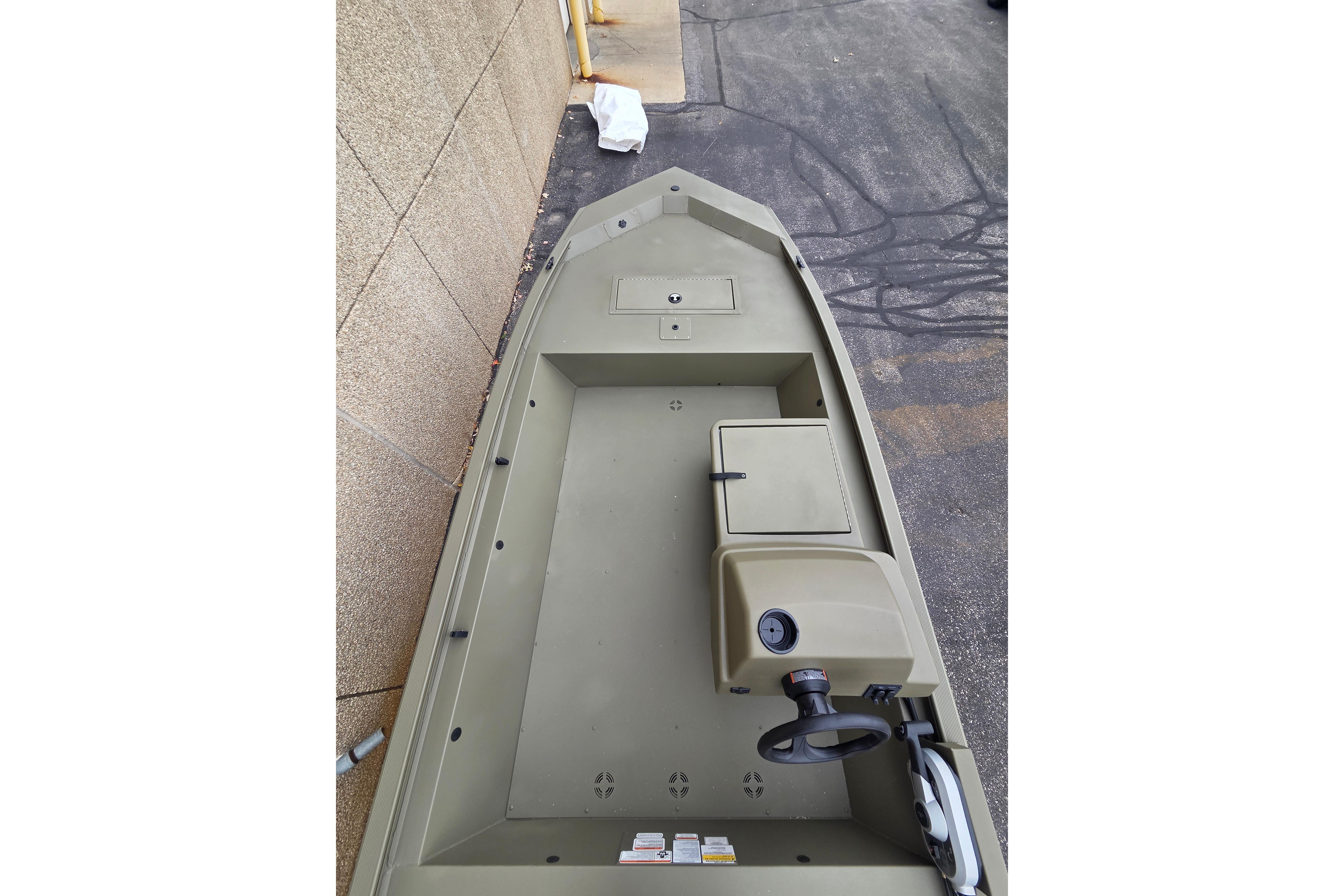 2026 Tracker Grizzly 1648 SC boat interior with steering console, parked on pavement.