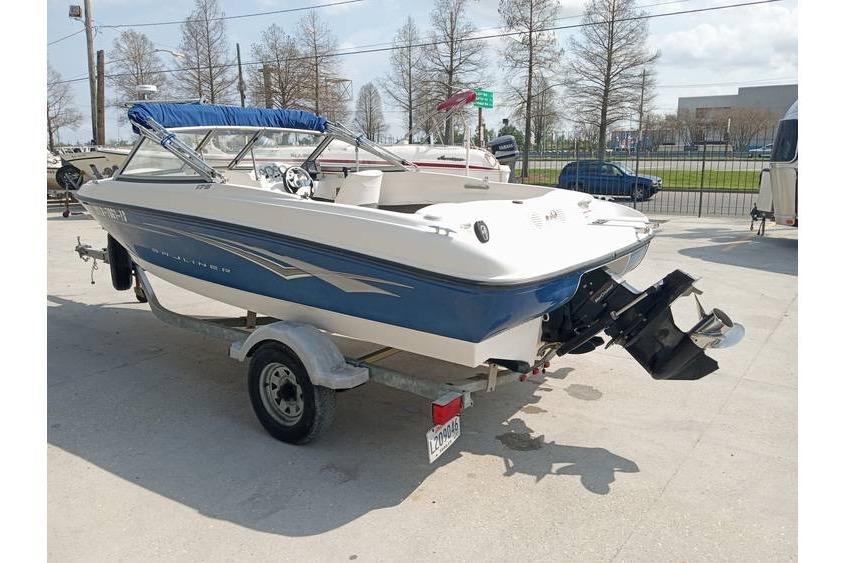 2008 Bayliner 175 boat on trailer, blue and white, parked outdoors.