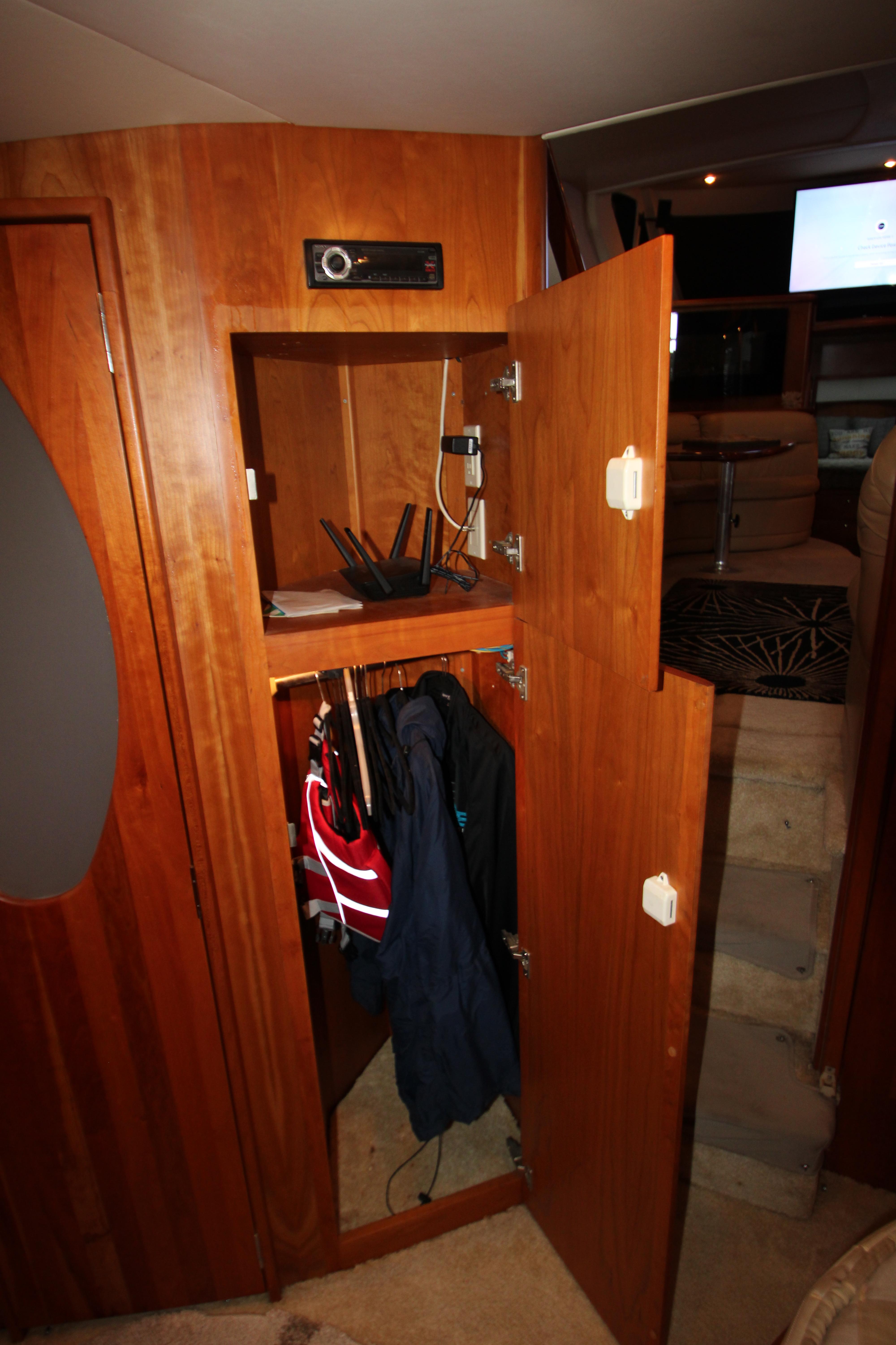 2002 Silverton 43 Motor Yacht interior closet with jackets and electronic equipment.