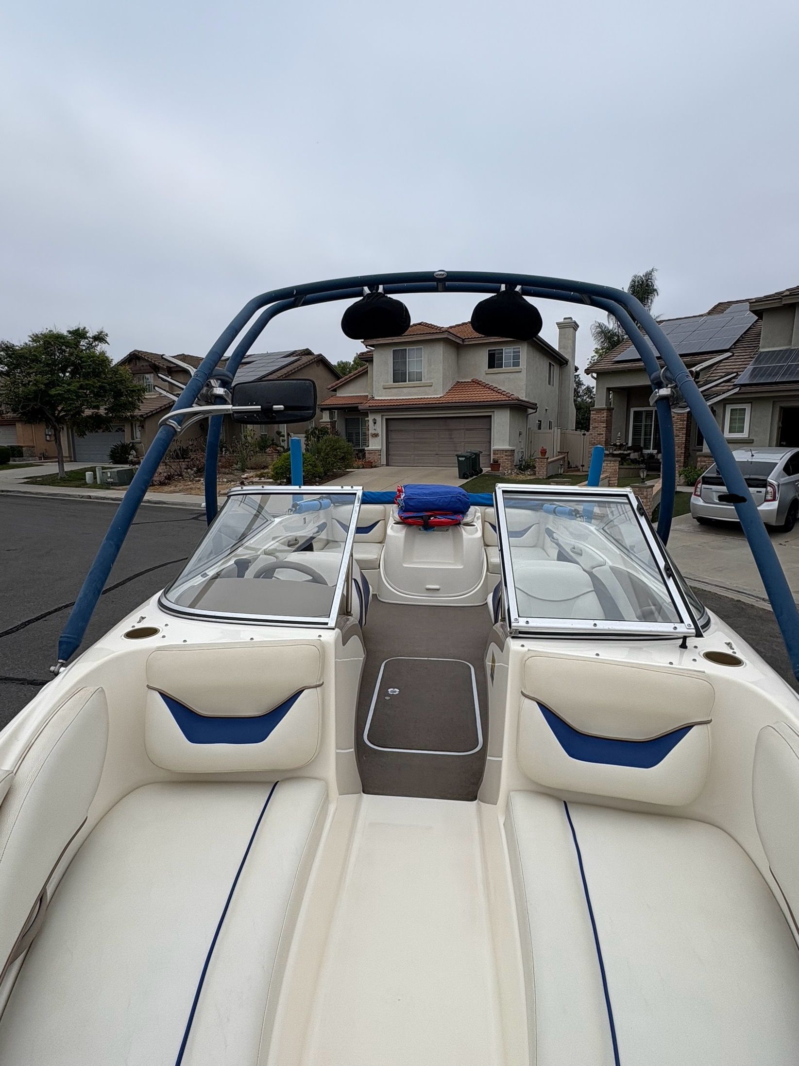 2003 Bayliner CAPRI 205 boat with open seating, parked in a residential neighborhood.