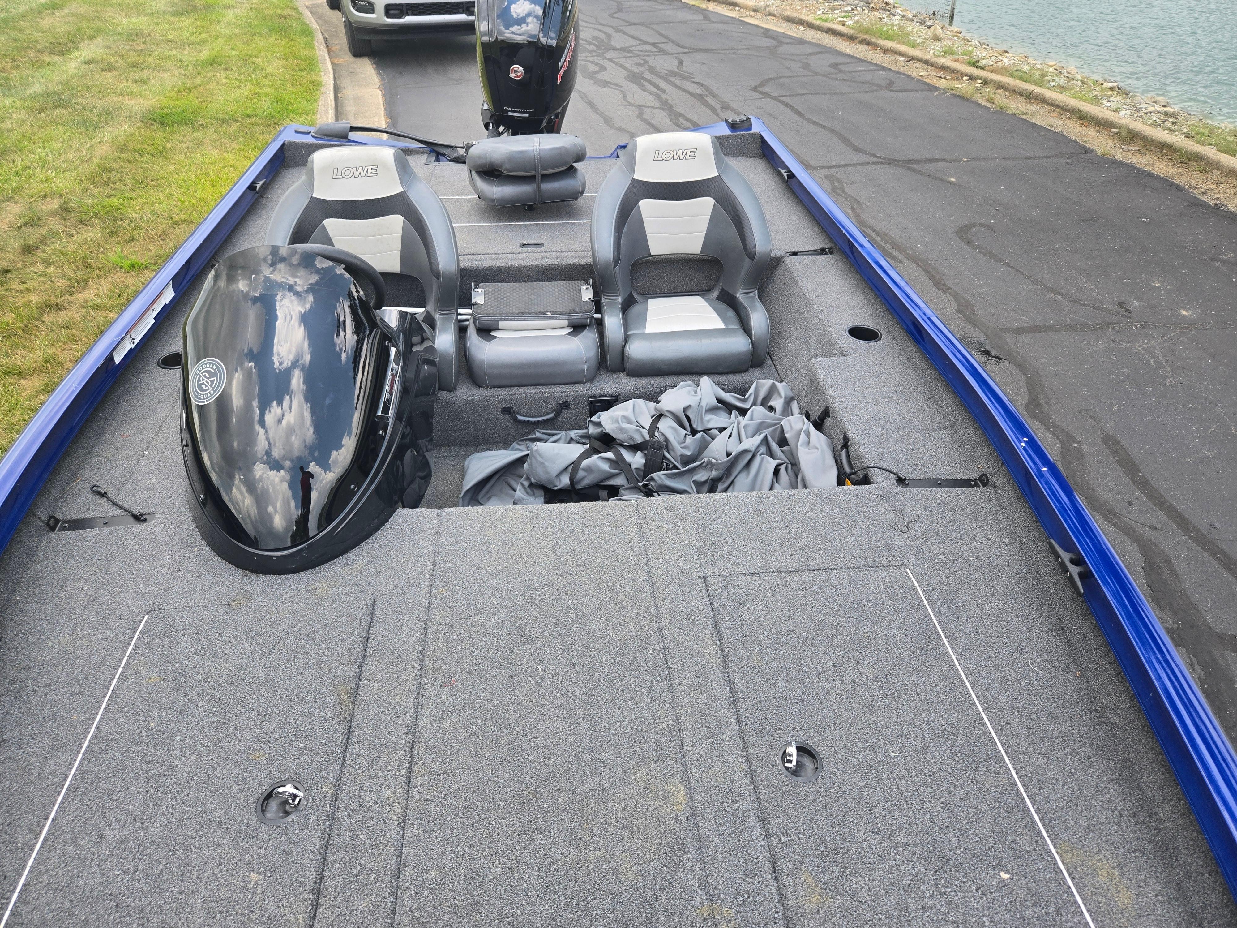 2021 Lowe Stinger 188 boat with dual seats and outboard motor, parked near water.