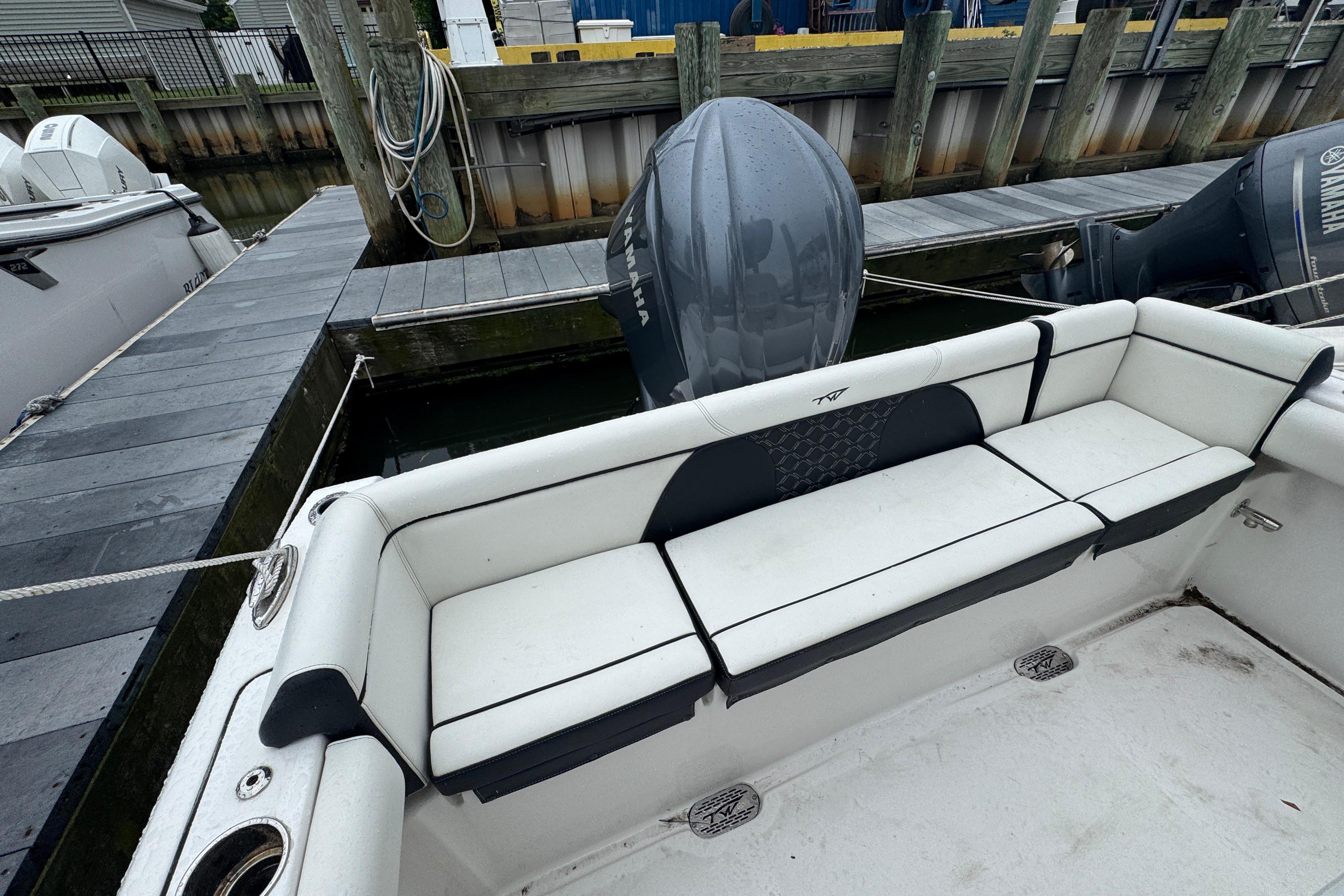 2022 Tidewater 232 SS boat with Yamaha outboard, docked with white seating.
