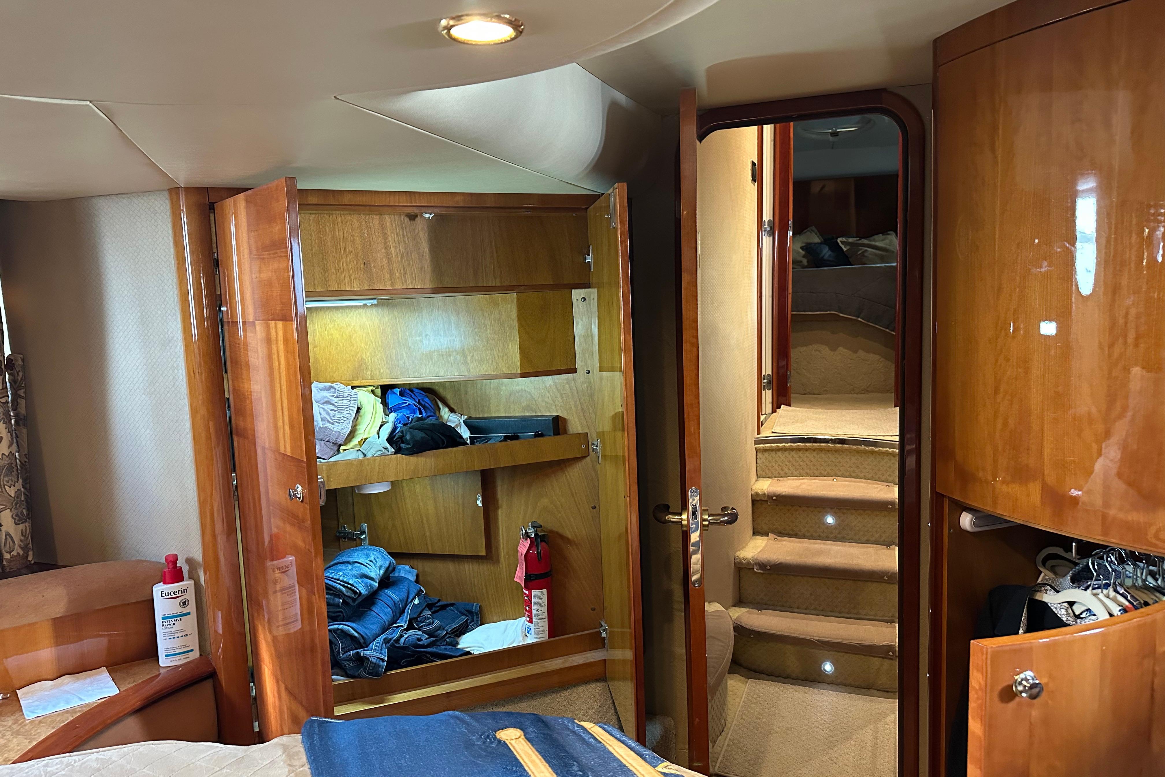 Luxurious interior of a 2004 Azimut 55E yacht with wooden cabinetry and cozy stairs.