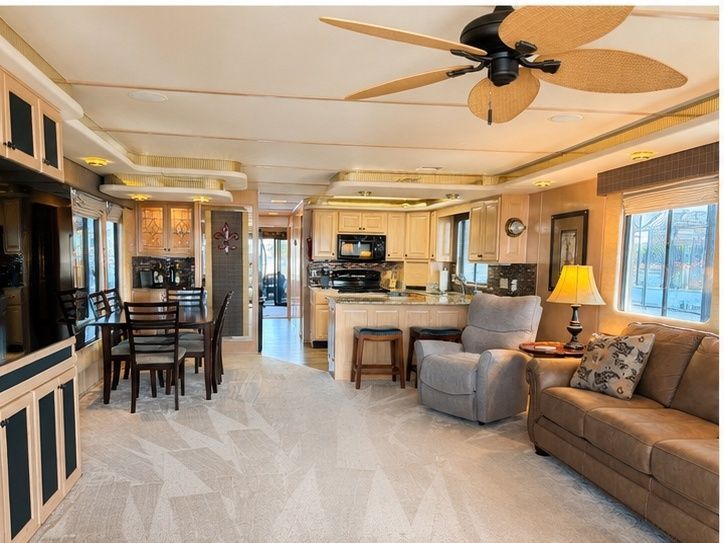 Interior of a spacious houseboat with kitchen, dining area, and living room.