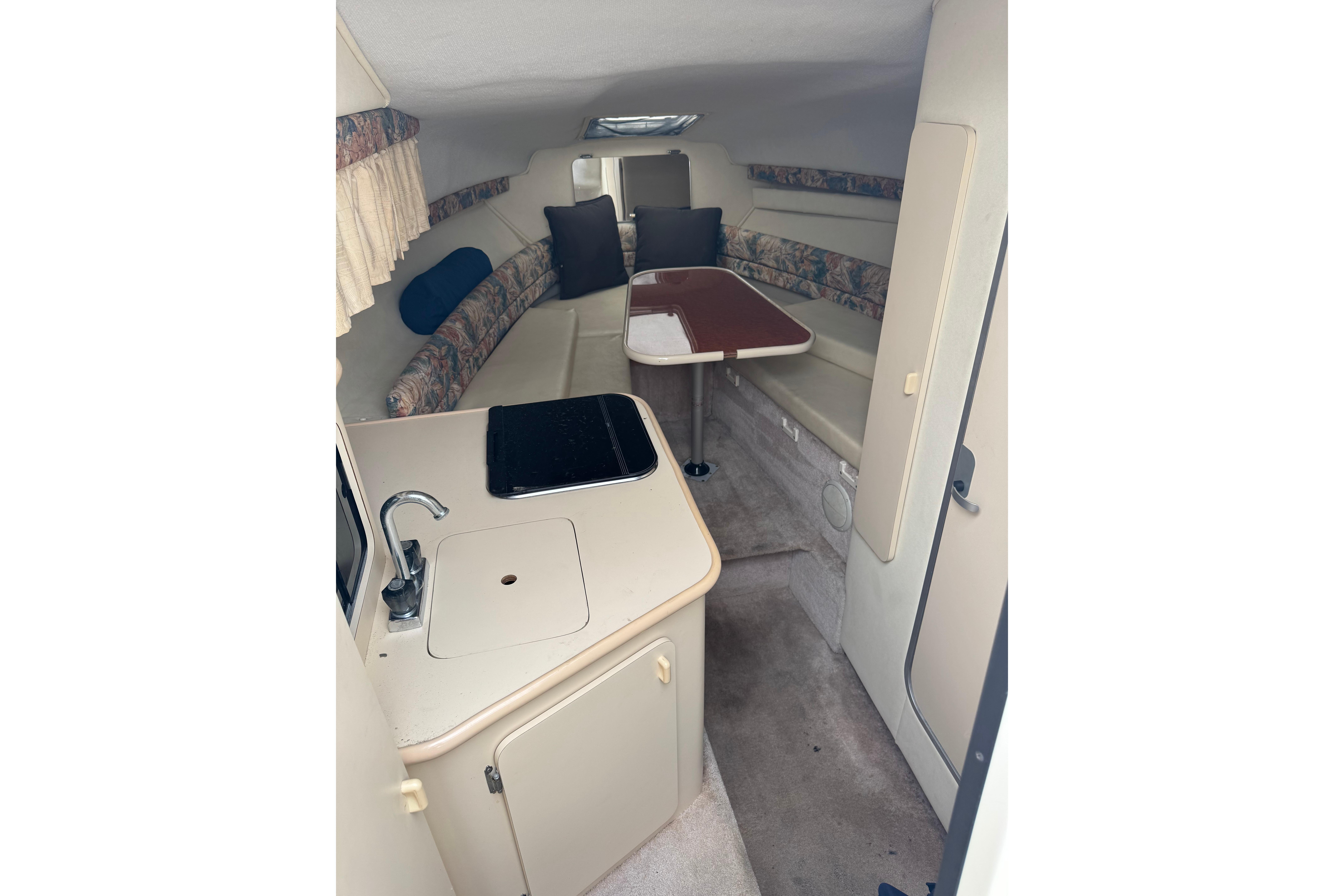 Interior of a 1997 Monterey 256 Cruiser boat with seating and kitchenette.