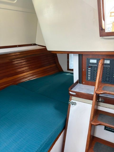Interior of a 1983 C&C Landfall with wood paneling and blue upholstery.
