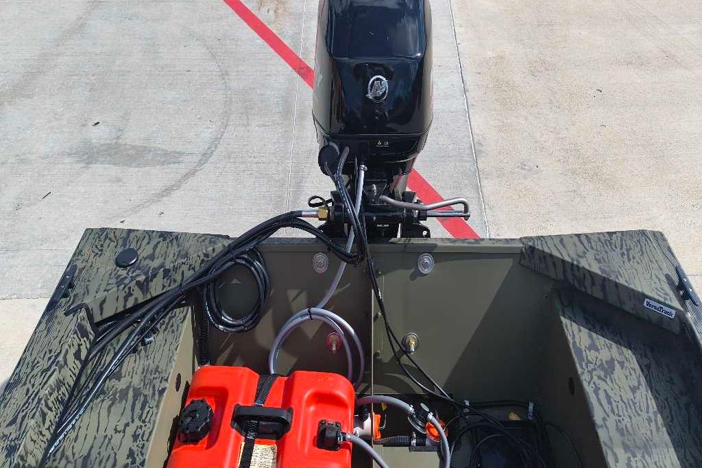 2026 Tracker Grizzly 1648 SC boat with motor and fuel tank on concrete surface.